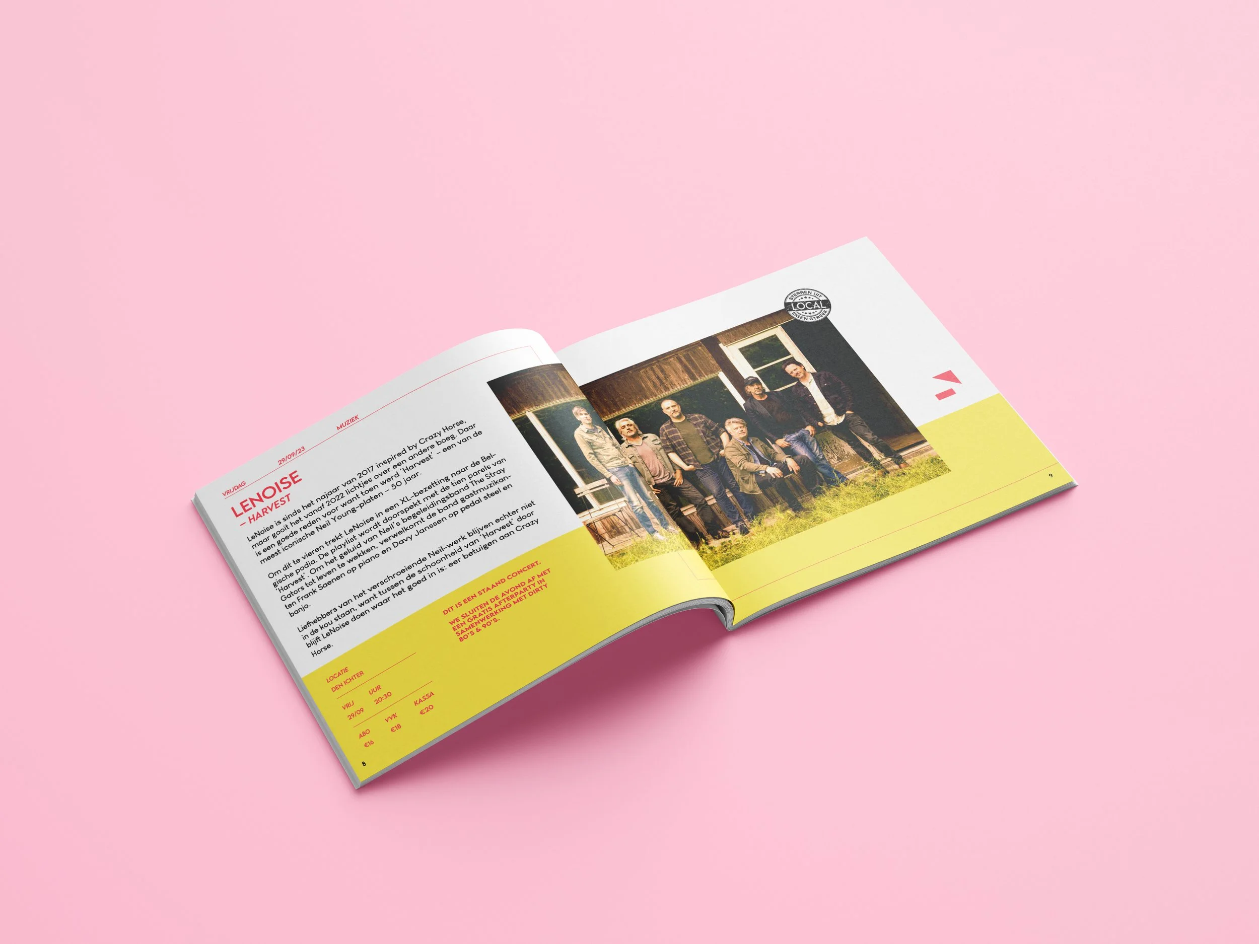 Open magazine featuring a band photo on the right page and text about the band on the left page, placed on a pink surface.