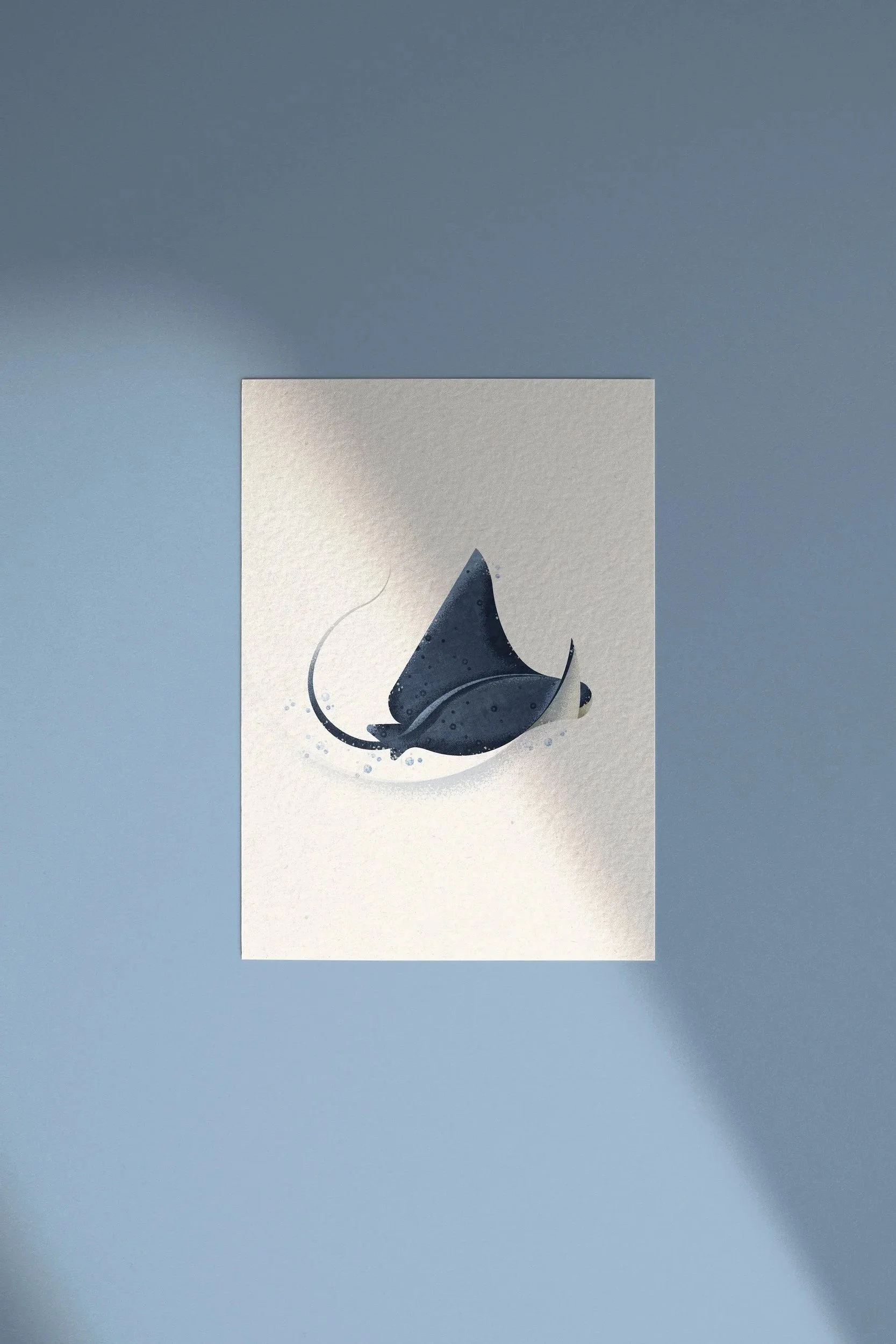 Artwork of a stylized black and white manta ray on textured paper with a light blue background.