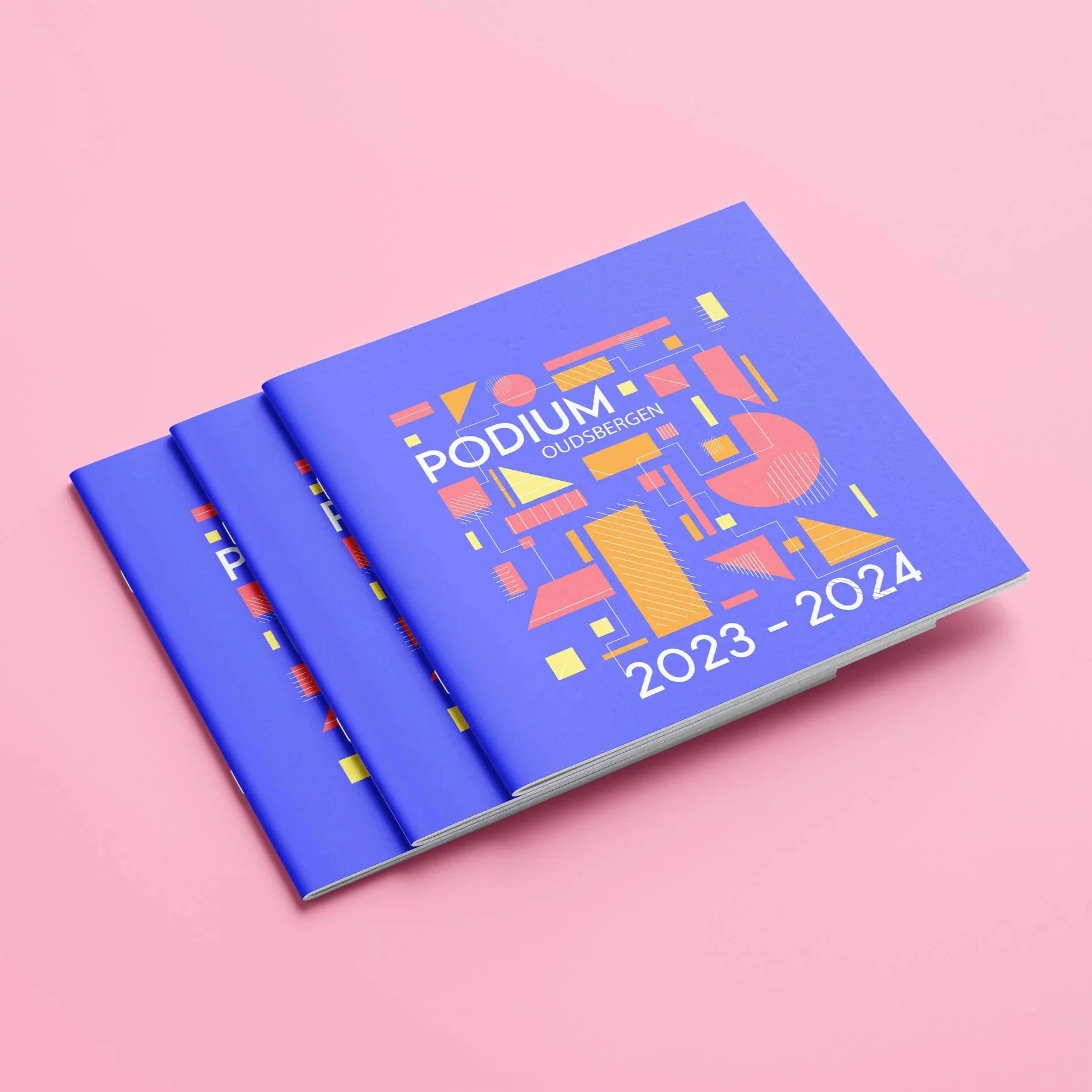 A set of blue brochures with colorful geometric designs on a pink background, labeled "PodiUM Oudbergen 2023-2024".