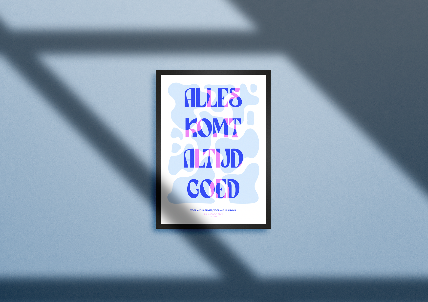 Framed poster on a blue wall with the message 'Alles Komt Altijd Goed' in bold blue and pink stylized letters, with abstract blue shapes in the background and smaller text below.