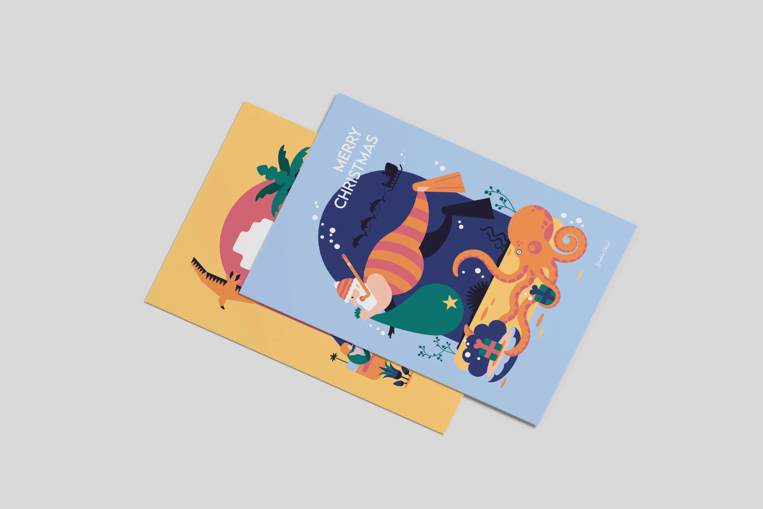 Two overlapping holiday greeting cards on a light gray background, featuring colorful, abstract illustrations of animals and festive elements.