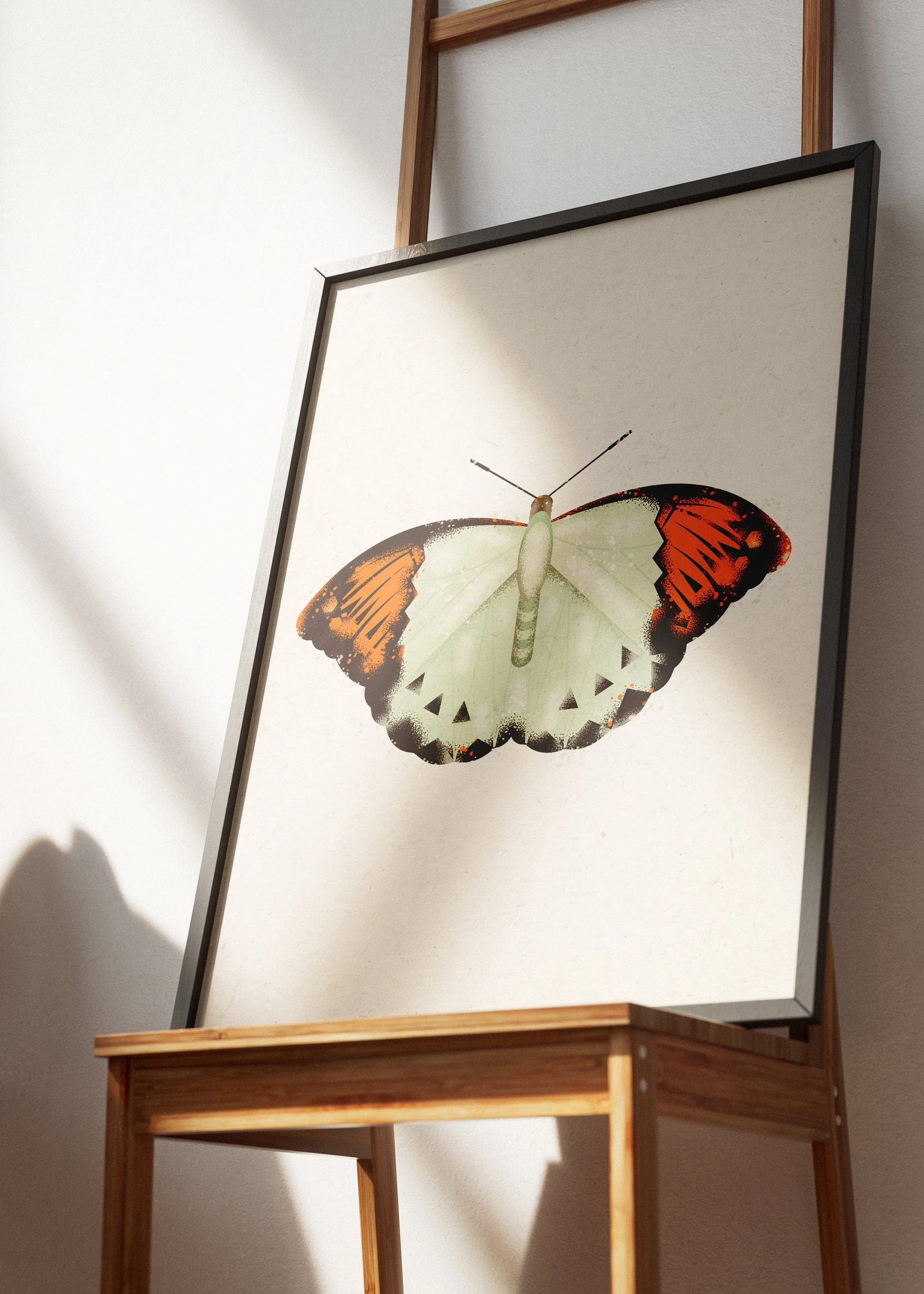 A butterfly-shaped clock with green and black details, mounted on a white background, on an easel with a wooden frame.