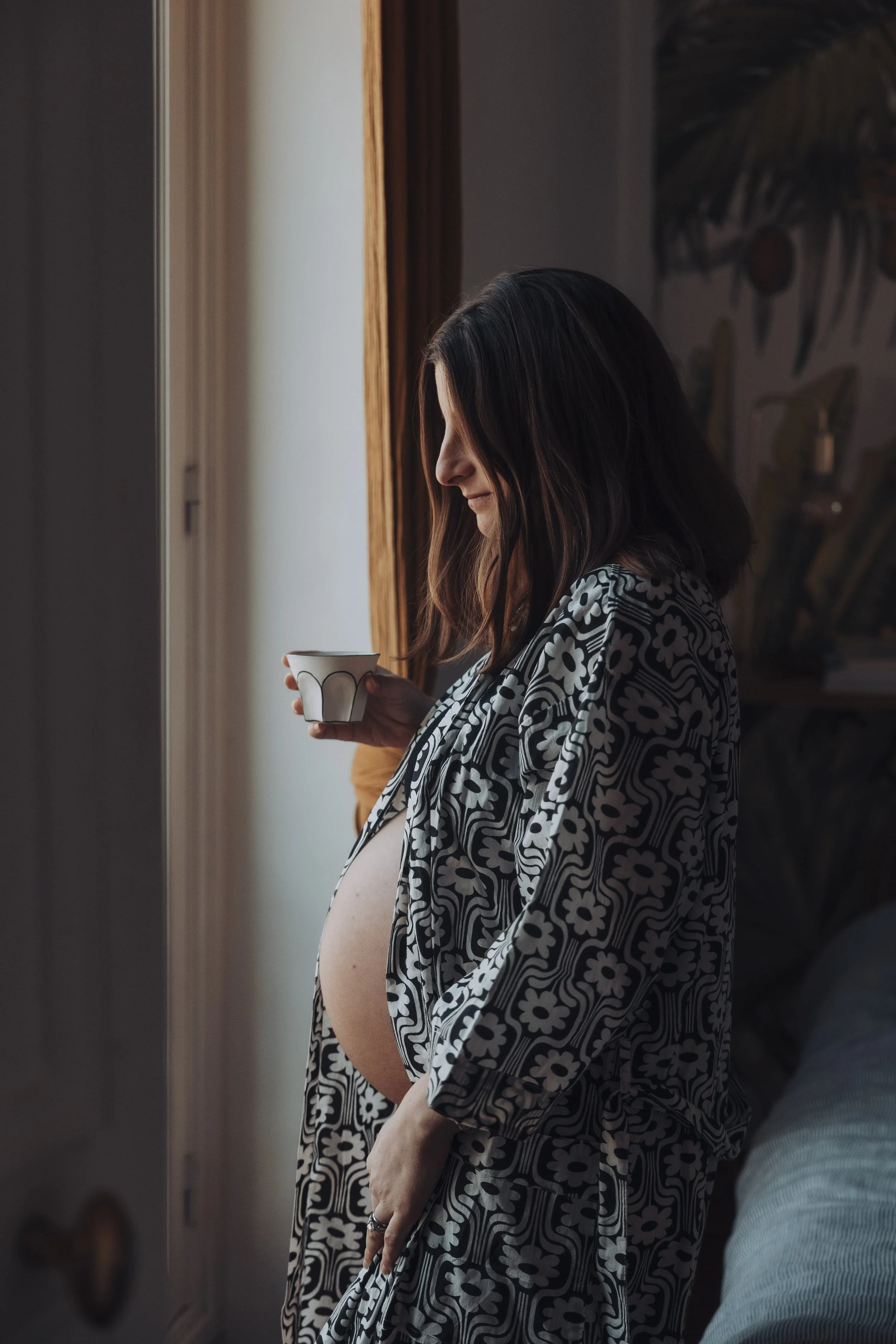 Une femme enceinte à paris bois son café
