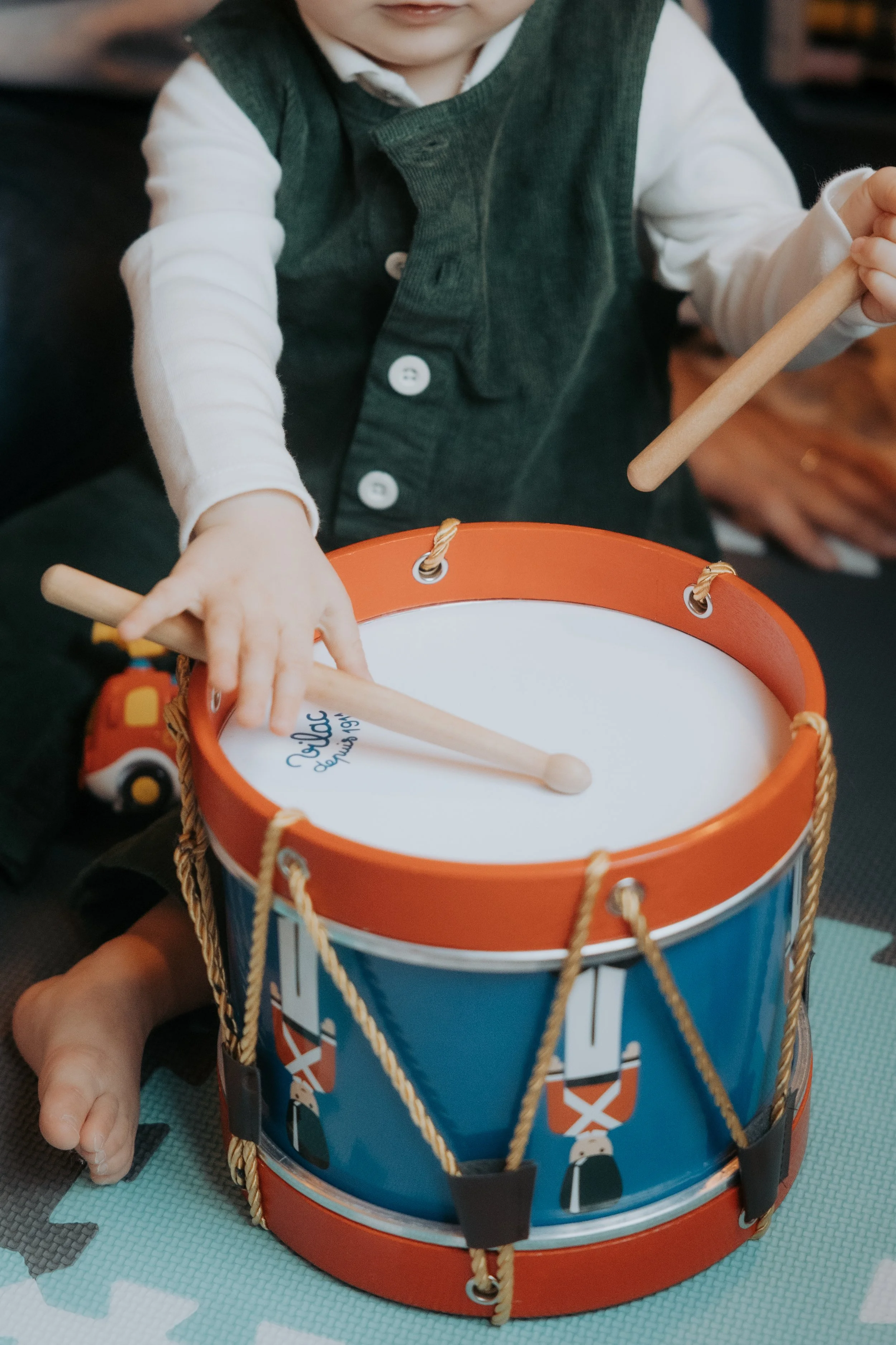 Un petit garcon joue du tambour lors d'une séance photo de famille à paris
