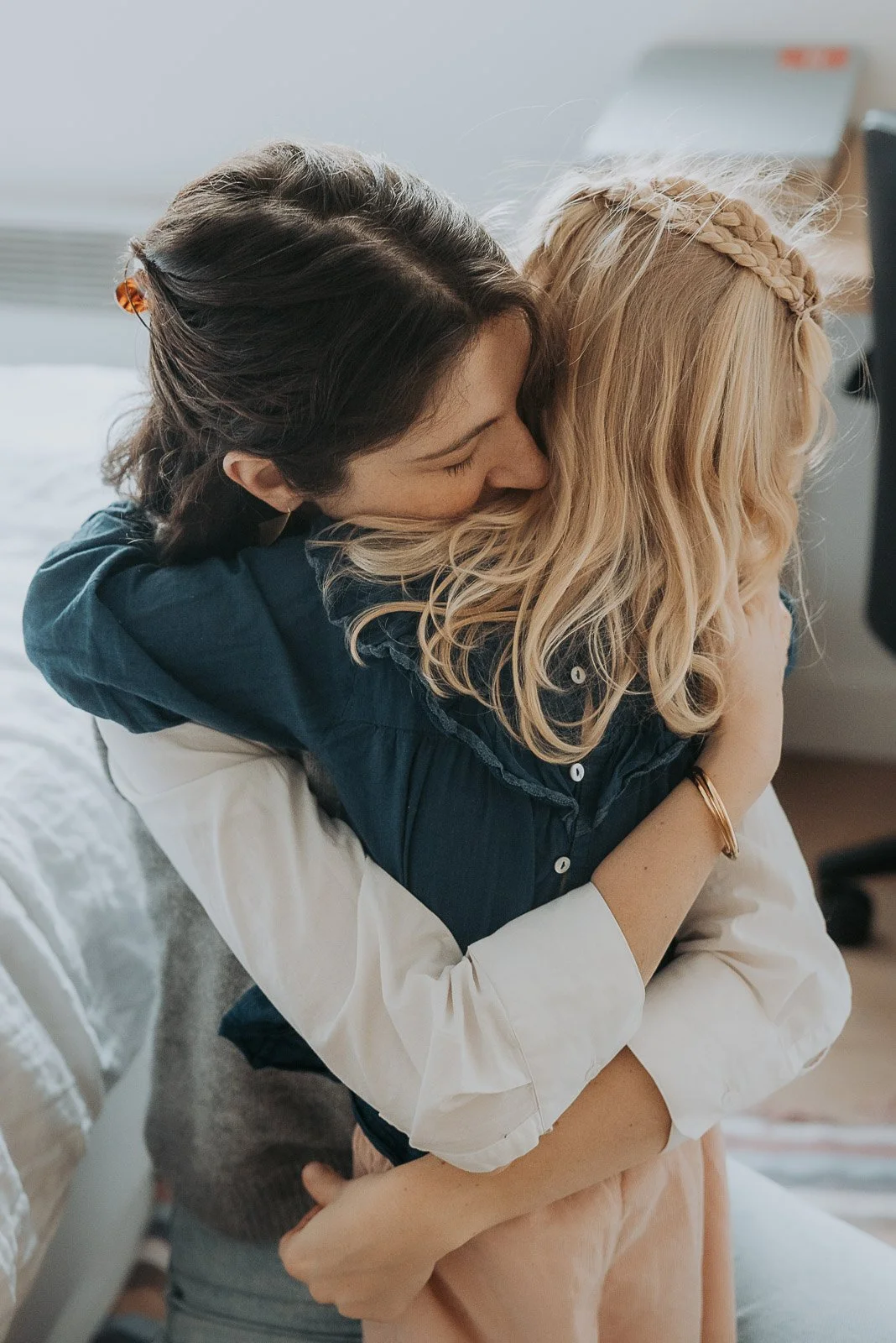 Une maman fait un calin à sa fille lors d'une séance photo de famille à paris