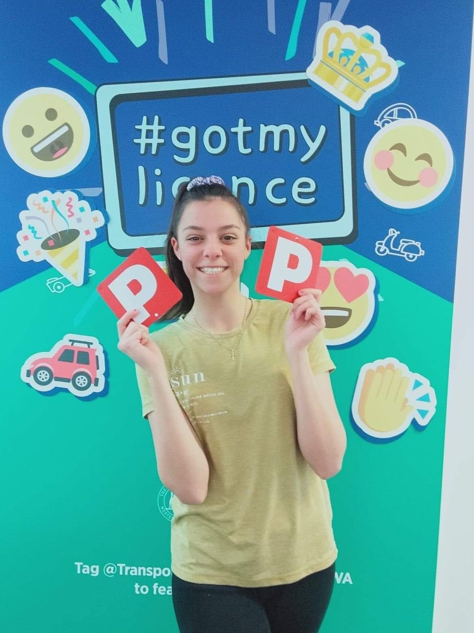 Victorious Driving School student Mackenzie holding their Red P plates after passing their PDA.