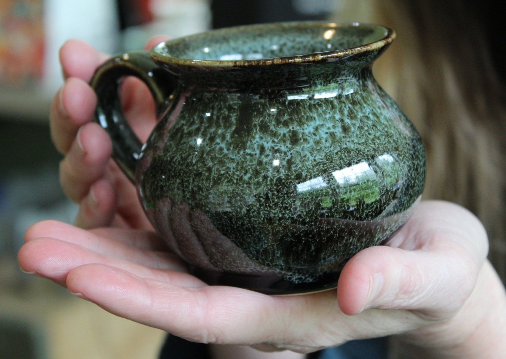Serpentine mug in potter's hands, 2025. Photography by Rakaia Kenney.