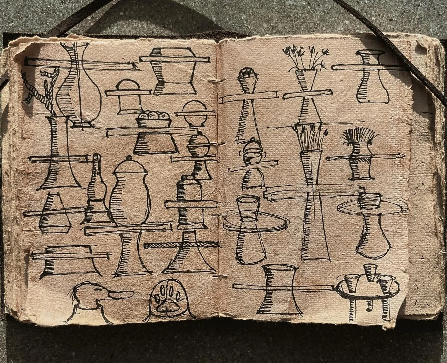 Sketches of various vases, bottles, and cups on open notebook pages with lines indicating their shapes.