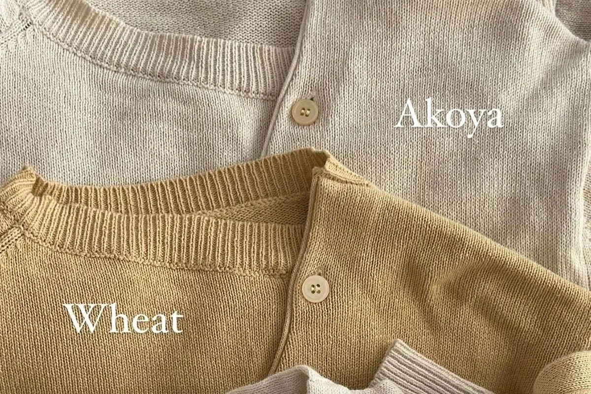 Bohème Goods The Asymmetric Knit cardigans in Akoya cream and Wheat yellow, shown overlapping with soft texture and button details.