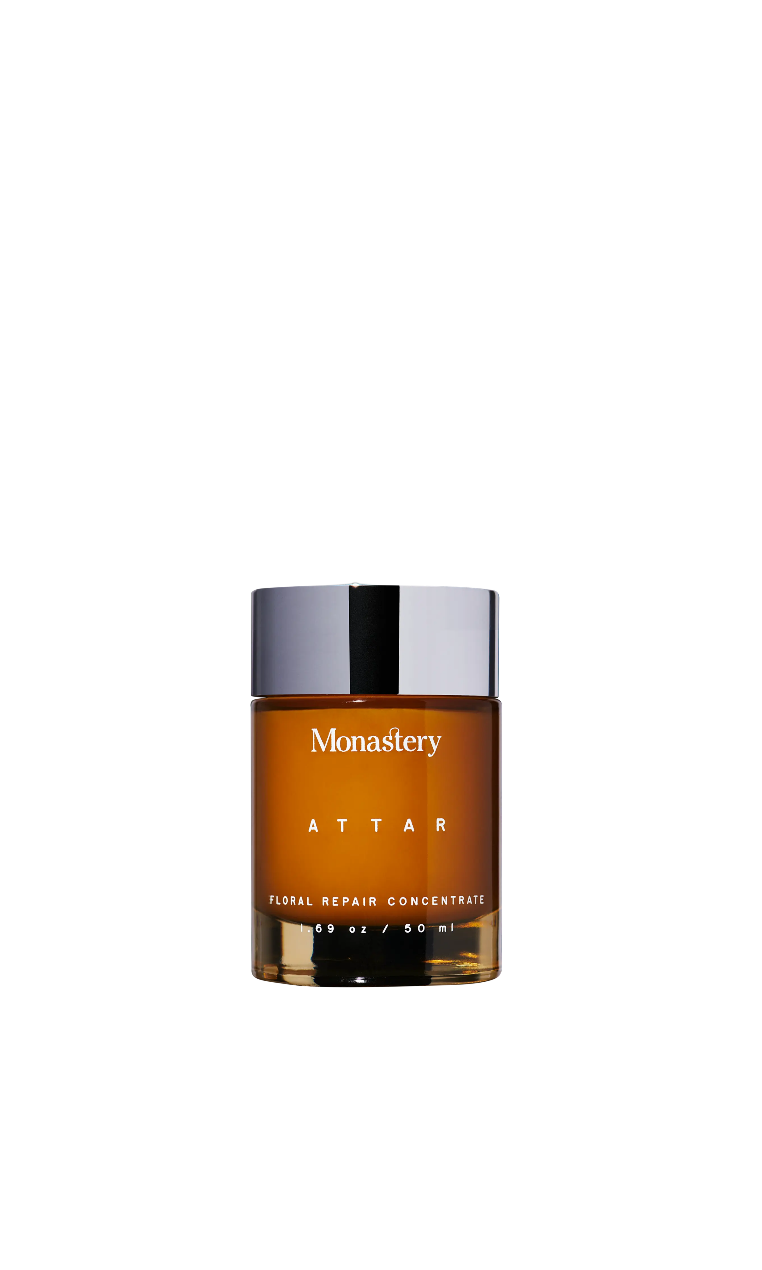 Close-up of Monastery Attar Balm bottle in amber glass with silver cap, labeled Floral Repair Concentrate 1.69 oz / 50 ml.