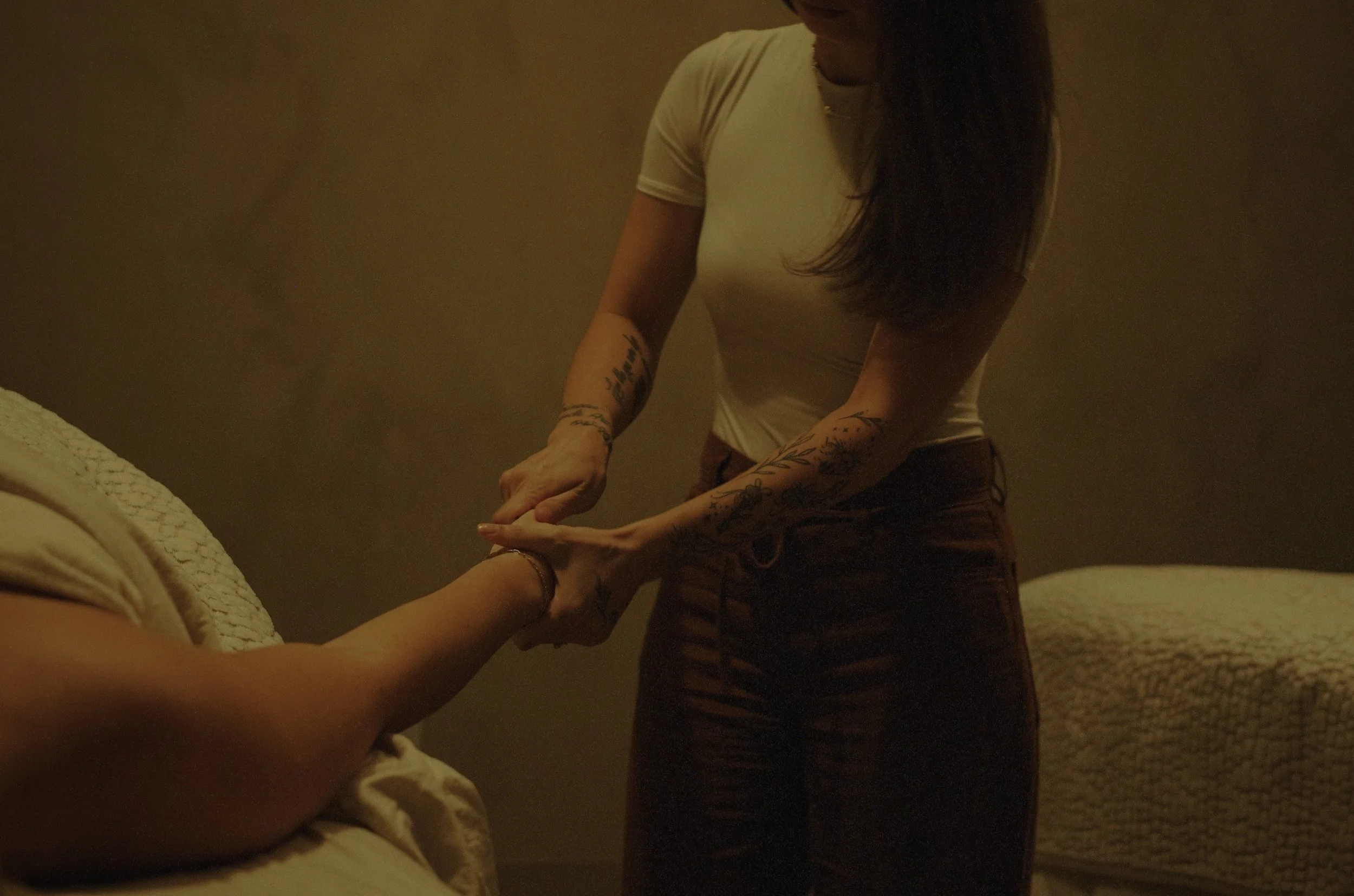 Spa professional performs hand and arm massage as part of body treatments in a serene room.