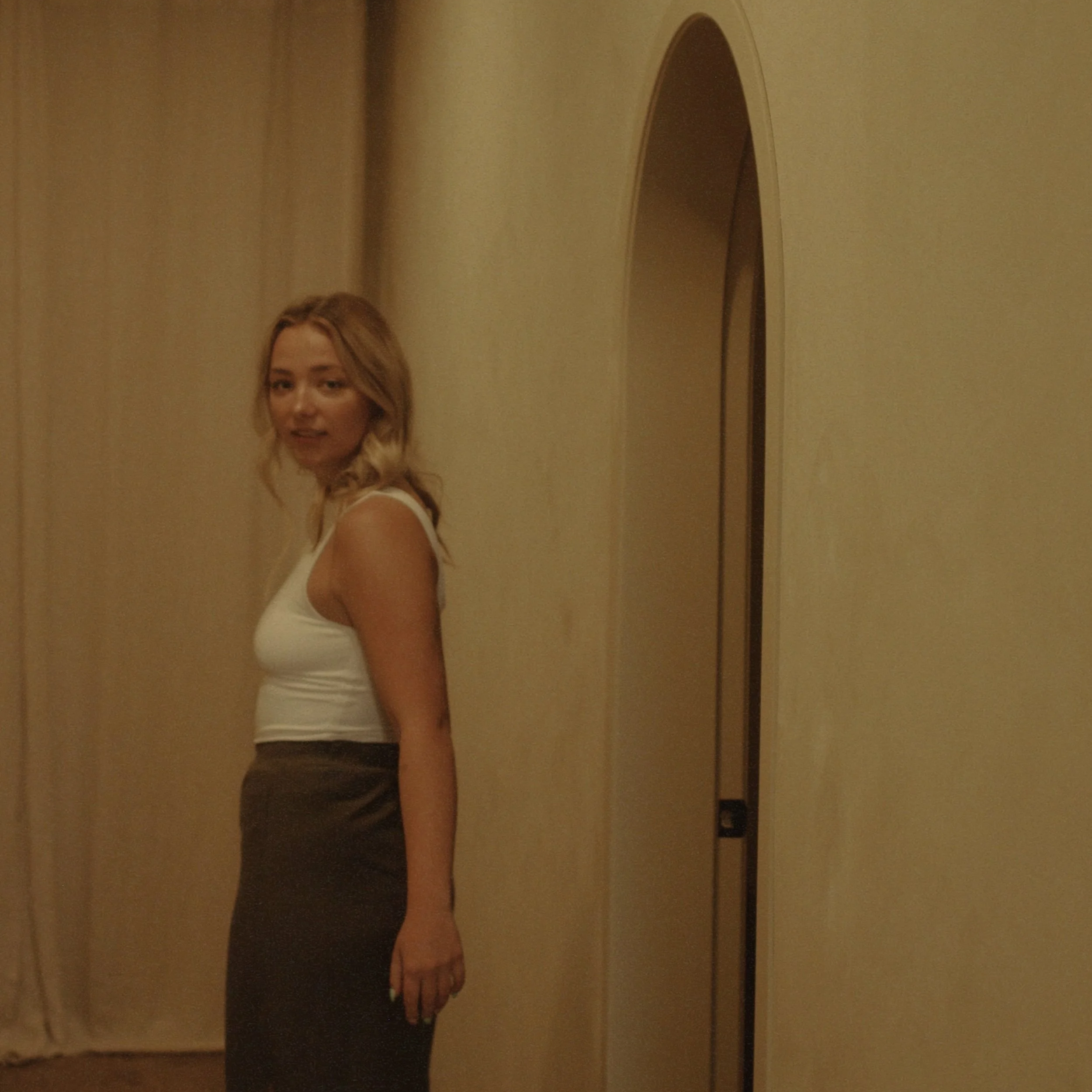 Kyra Lacombes spa receptionist looks over her shoulder coming out of spa room