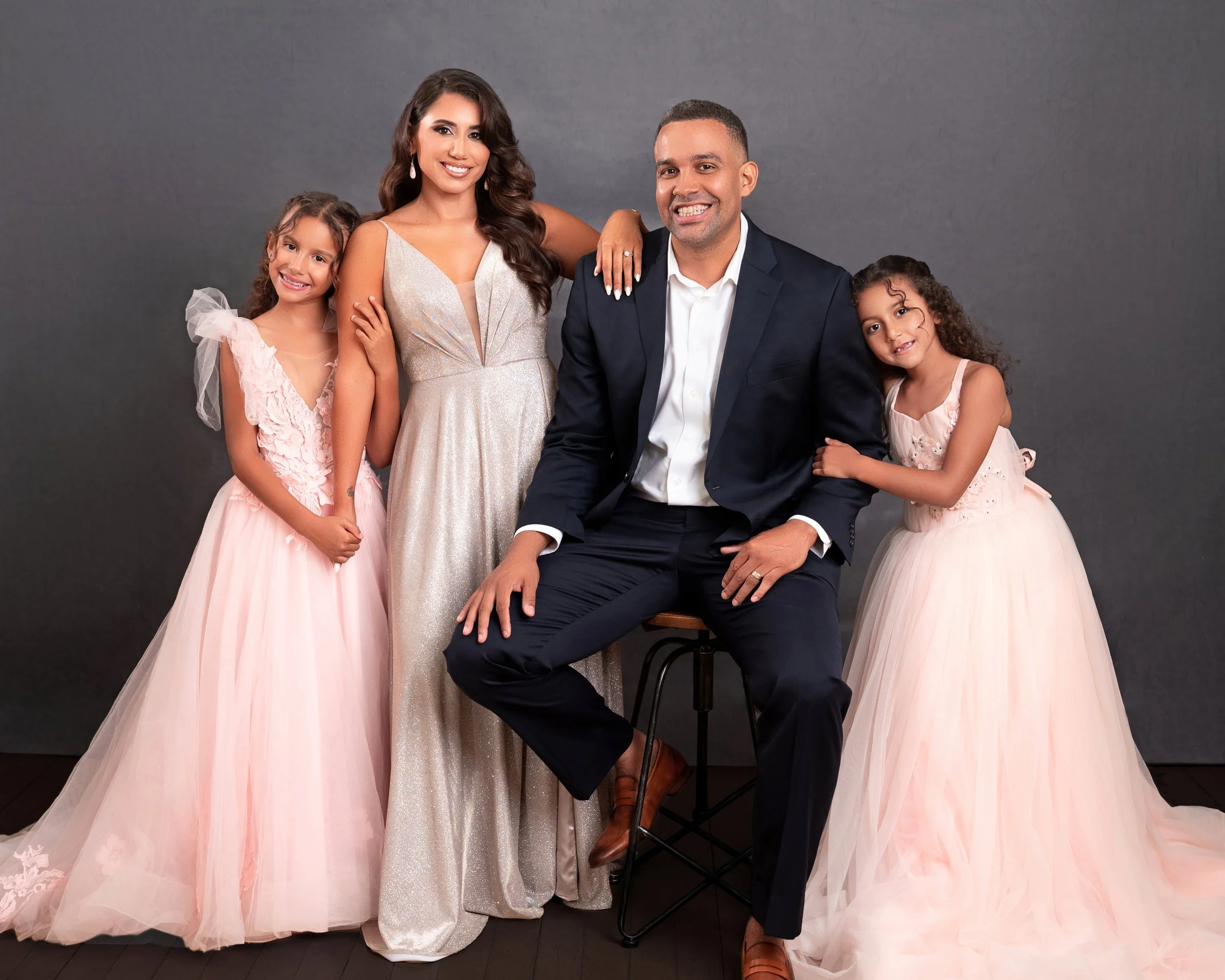 San Antonio family photographer studio portrait of parents with two young daughters in formal dresses.