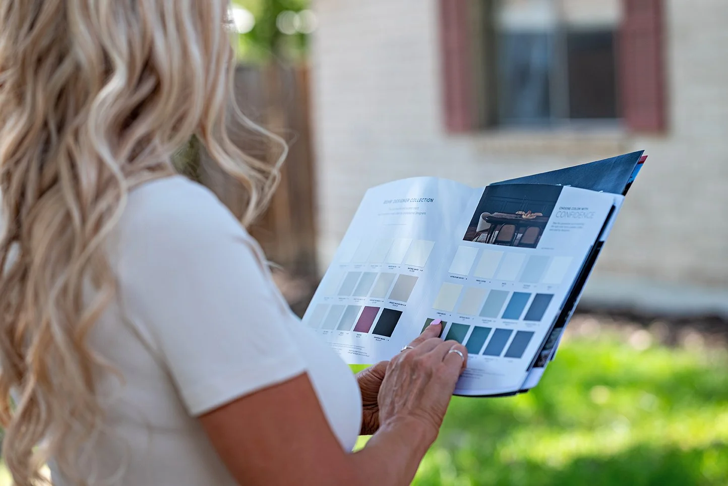 Jodi reviewing paint color samples outside a home during her personal branding session.