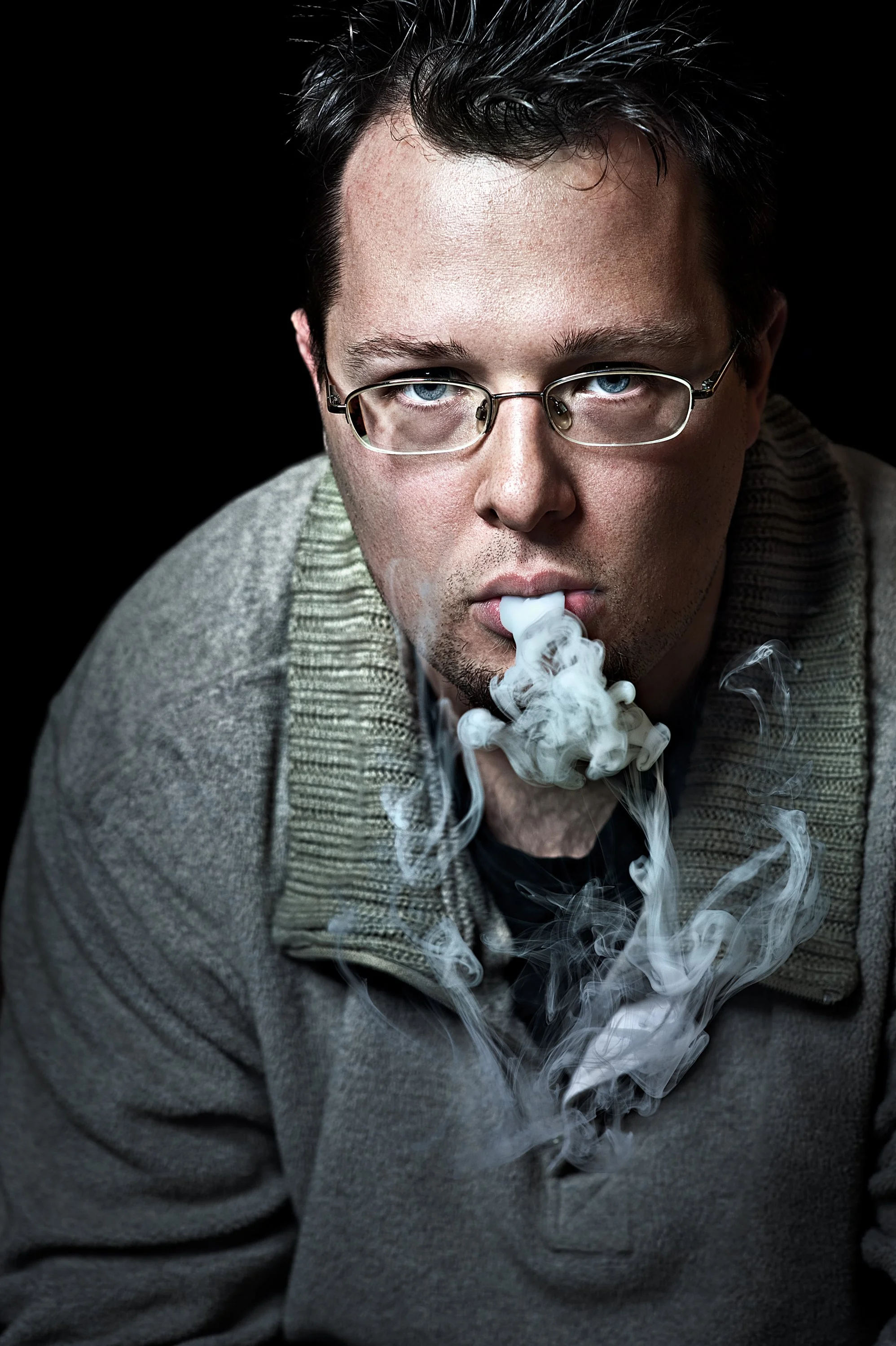 Intense Portrait of a man blowing smoke