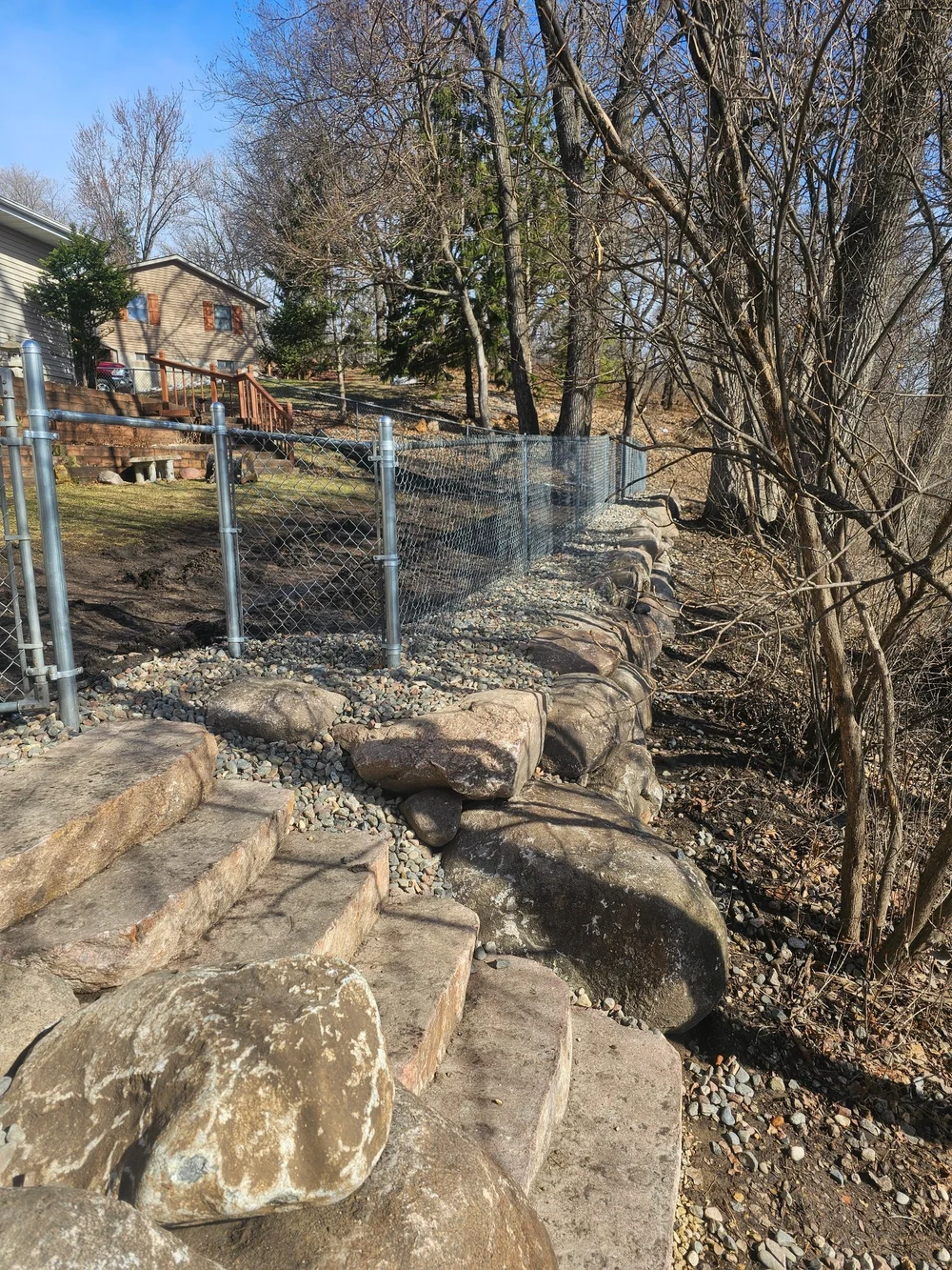 Completed boulder wall and natural stone steps for pond access — Woodbury MN — Heritage Outdoors 2025
