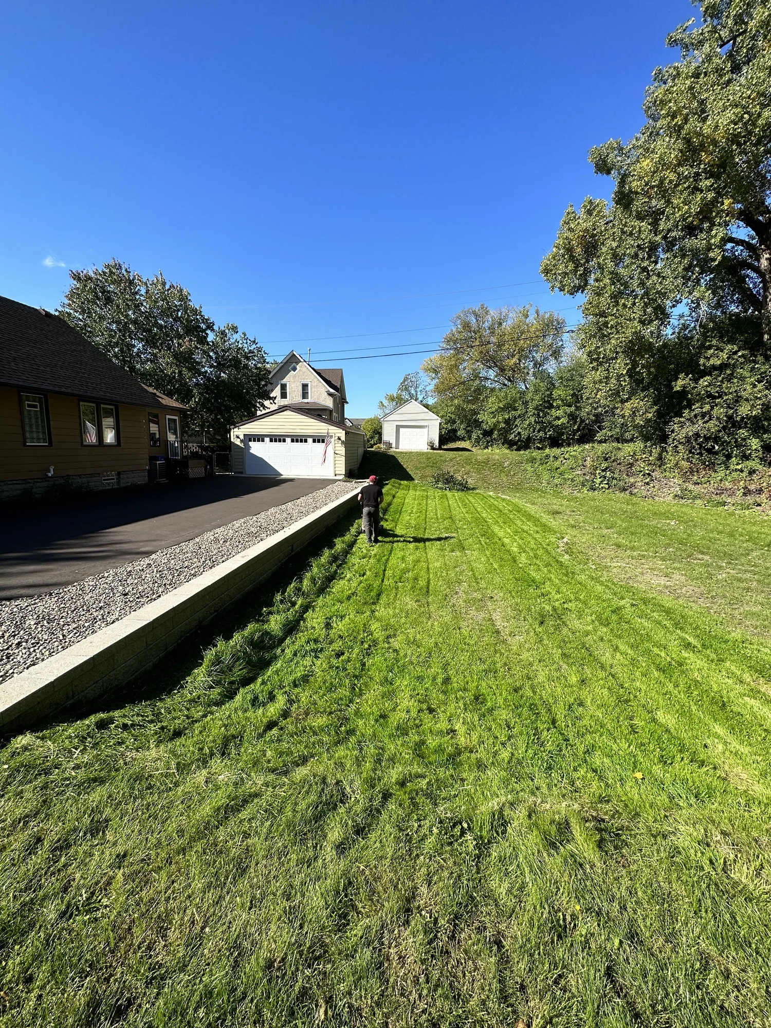 Completed Versa-Lok Standard retaining wall along driveway edge with river rock cap — Como Park Saint Paul MN — Heritage Outdoors