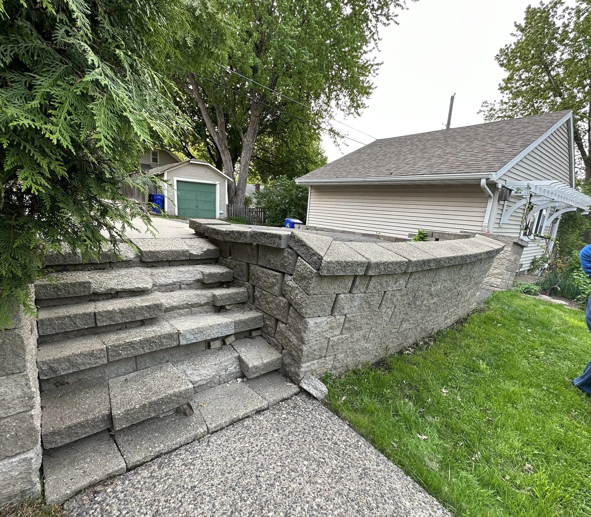 Failing Versa-Lok retaining wall with spray paint layout marking new patio area — Como Park Saint Paul MN