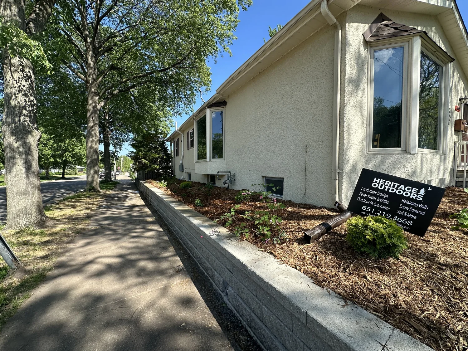 Versa-Lok retaining wall with plant design and hardwood mulch installed — Longfellow Minneapolis MN — Heritage Outdoors spring 2024