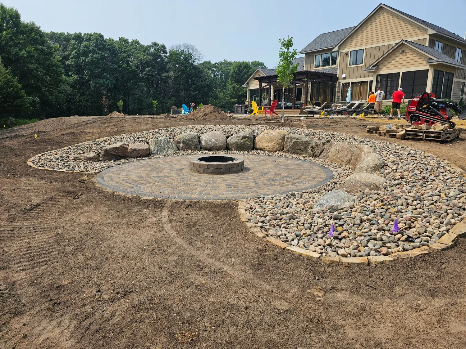 Boulder wall paver circle river rock firepit full view — Mahtomedi MN — Heritage Outdoors 2023