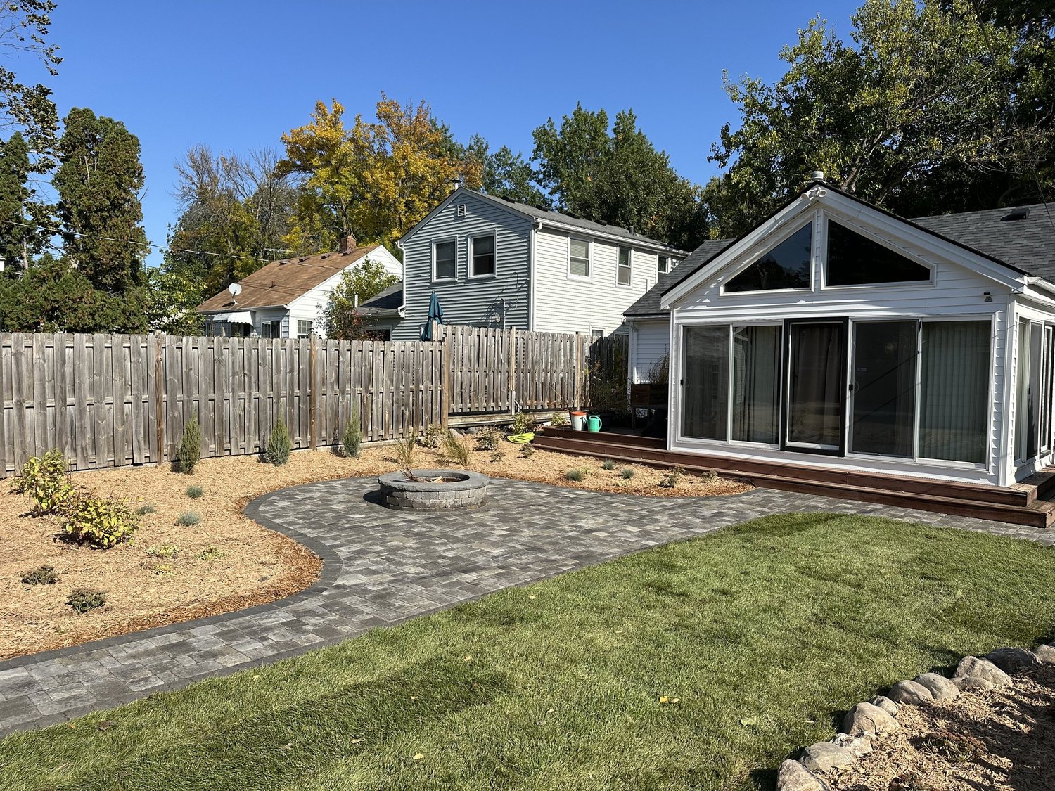 Completed backyard with patio, sod, and planting beds toward sunroom — Como Park Saint Paul — Heritage Outdoors 2025