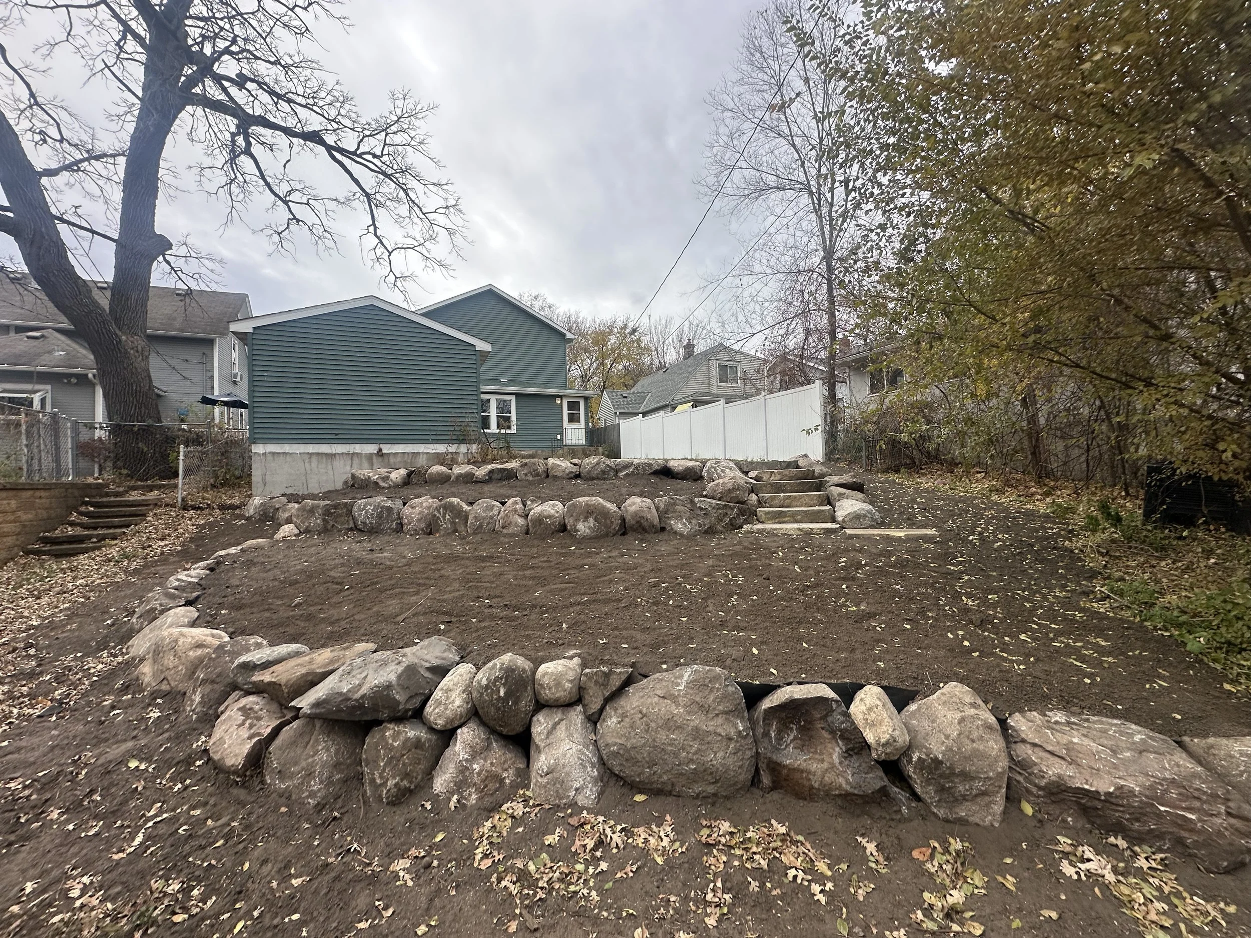 Tiered boulder retaining wall and natural stone steps — Saint Anthony Park, Saint Paul MN — Heritage Outdoors 2025