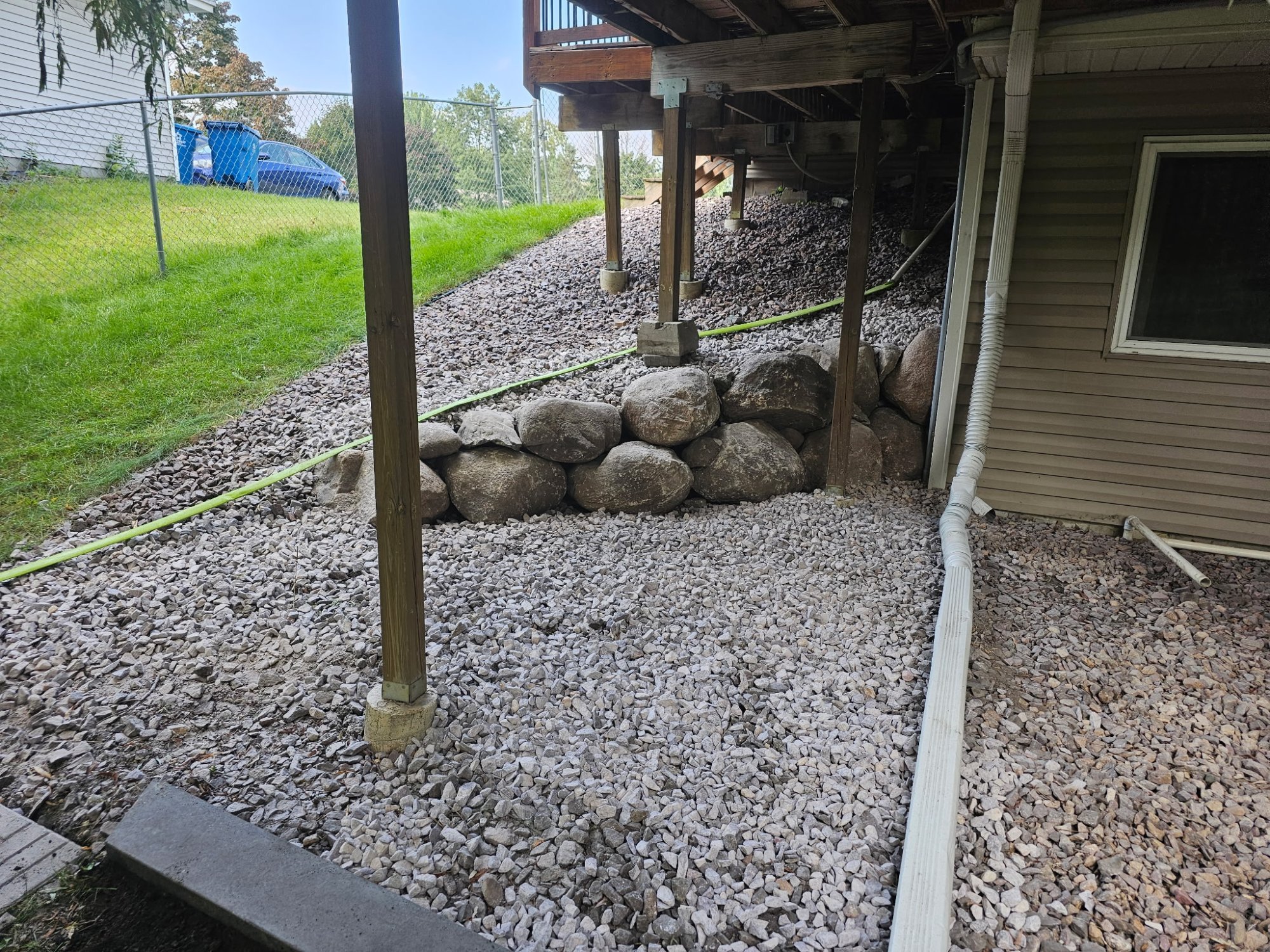 Completed natural boulder retaining wall replacing timber wall under deck — Centerville MN — Heritage Outdoors
