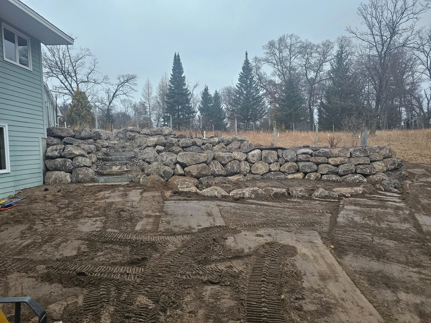 After — completed tiered fieldstone boulder wall — Wyoming MN — Heritage Outdoors