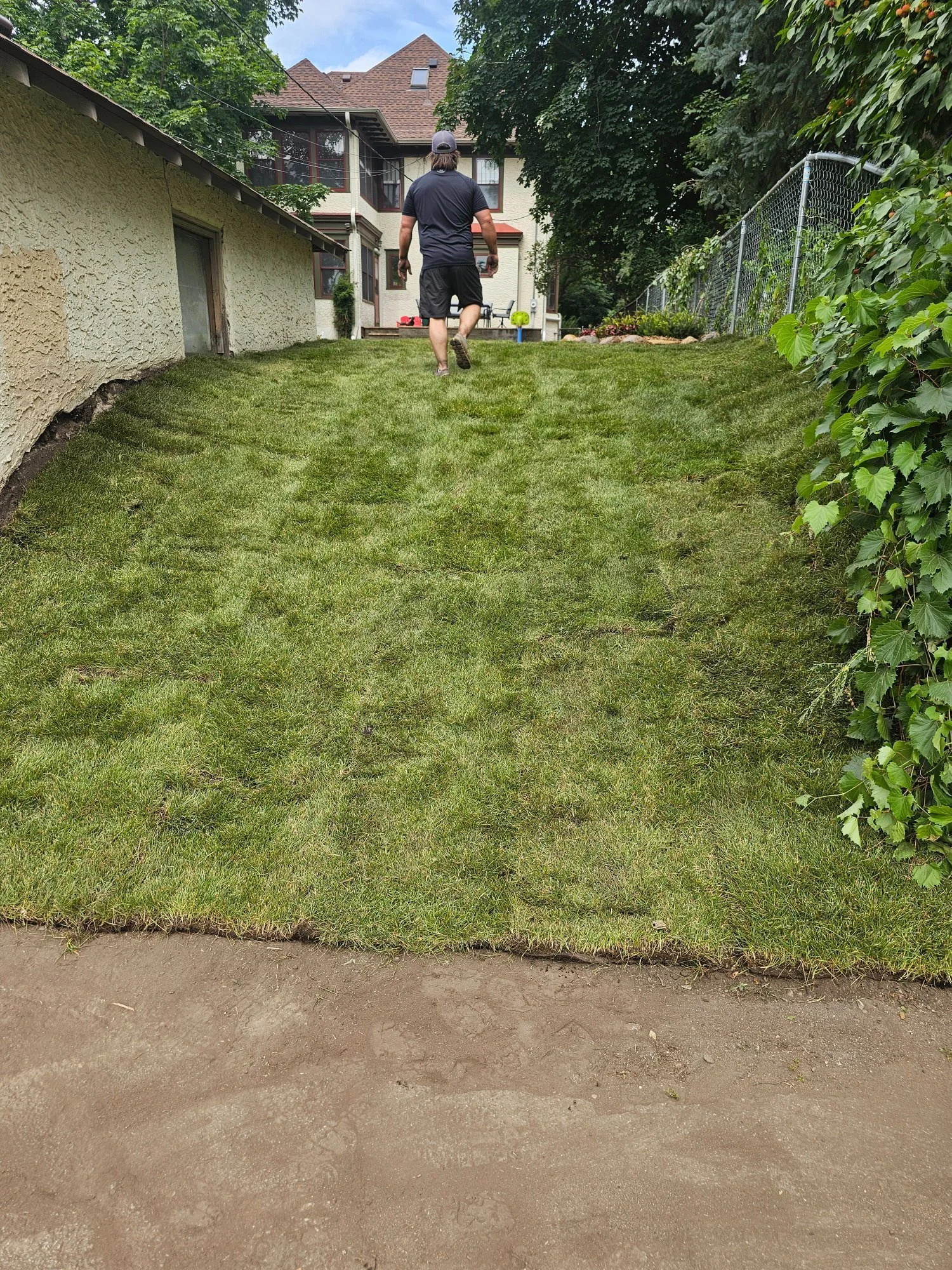 Jacob walking up the completed sodded hill — Summit Hill Saint Paul MN — Heritage Outdoors 2025