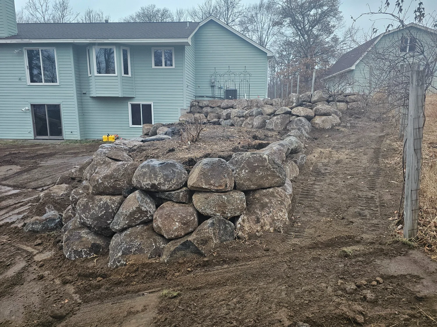 Full length of completed boulder wall running along property — Wyoming MN — Heritage Outdoors