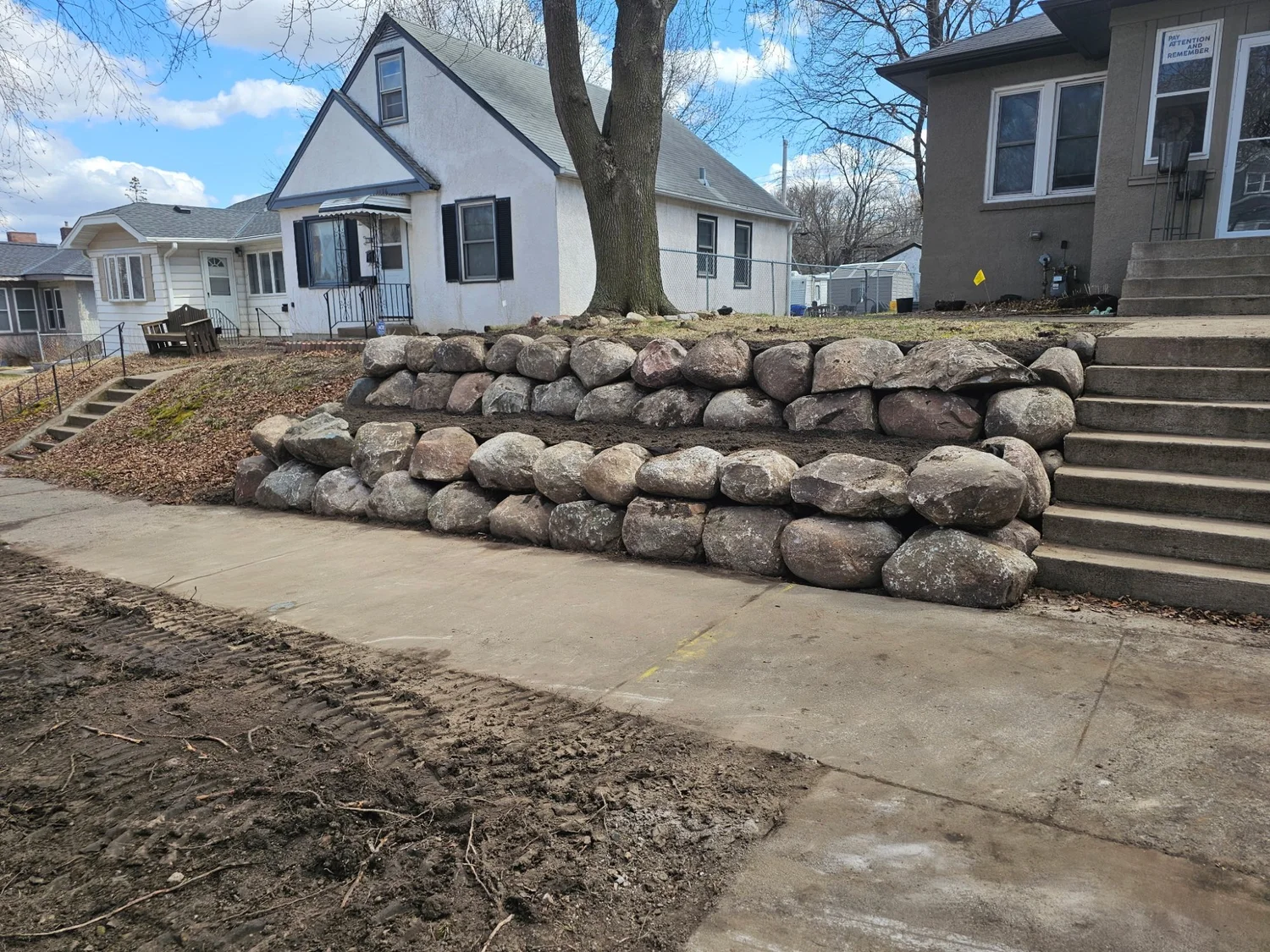 Completed double-tier fieldstone boulder wall — Maplewood MN front yard — Heritage Outdoors