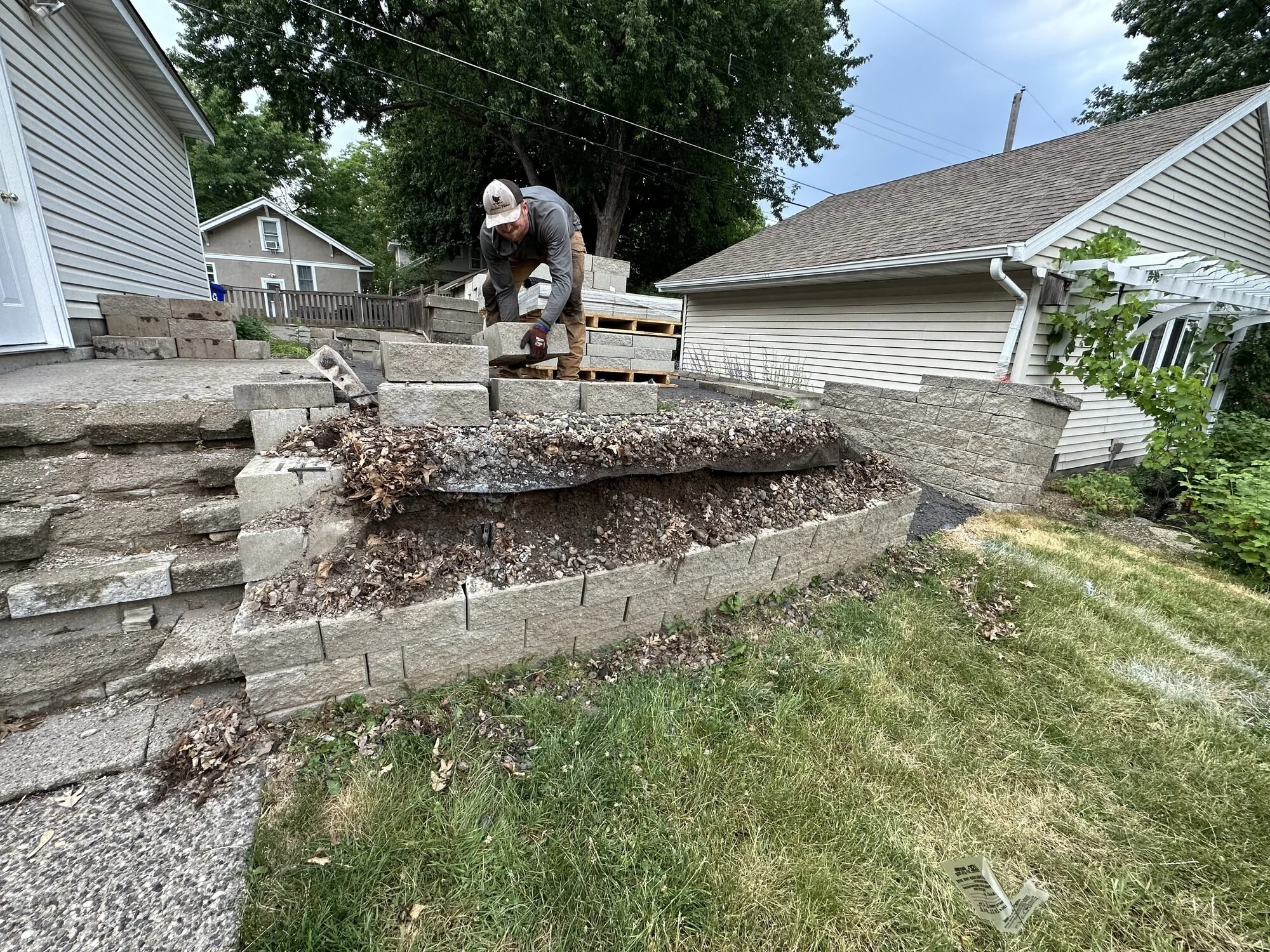 Versa-Lok retaining wall demolition in progress — old block wall halfway removed — Como Park Saint Paul MN — Heritage Outdoors