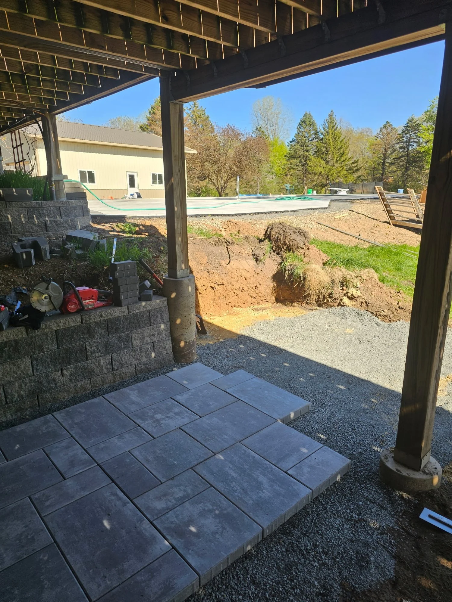 Paver walkway and pool deck under construction viewed from pergola — Lake Elmo MN — Heritage Outdoors