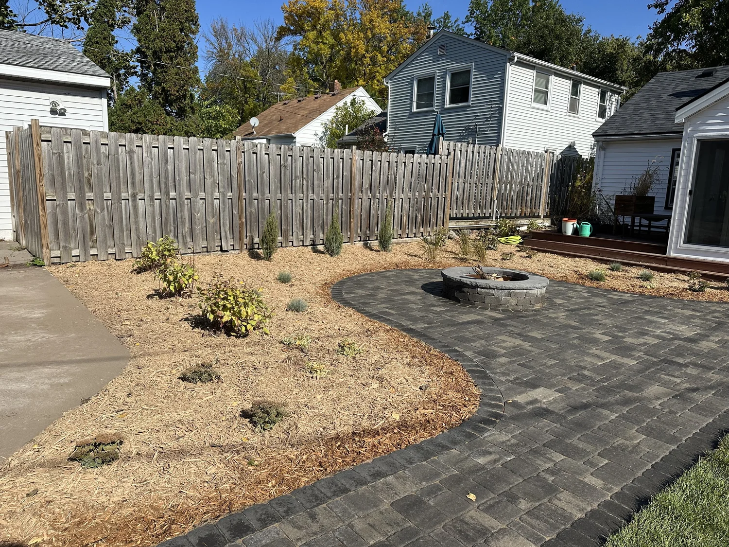 Completed paver patio and fire pit with wide mulch beds view — Como Park Saint Paul — Heritage Outdoors 2025