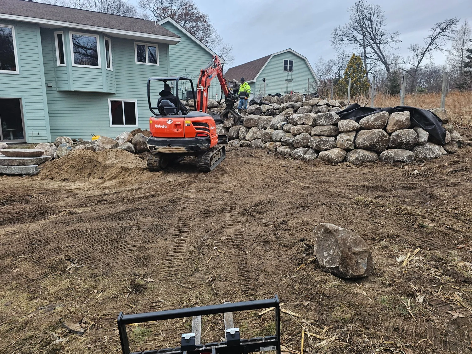 Boulder wall courses being placed during installation — Wyoming MN — Heritage Outdoors