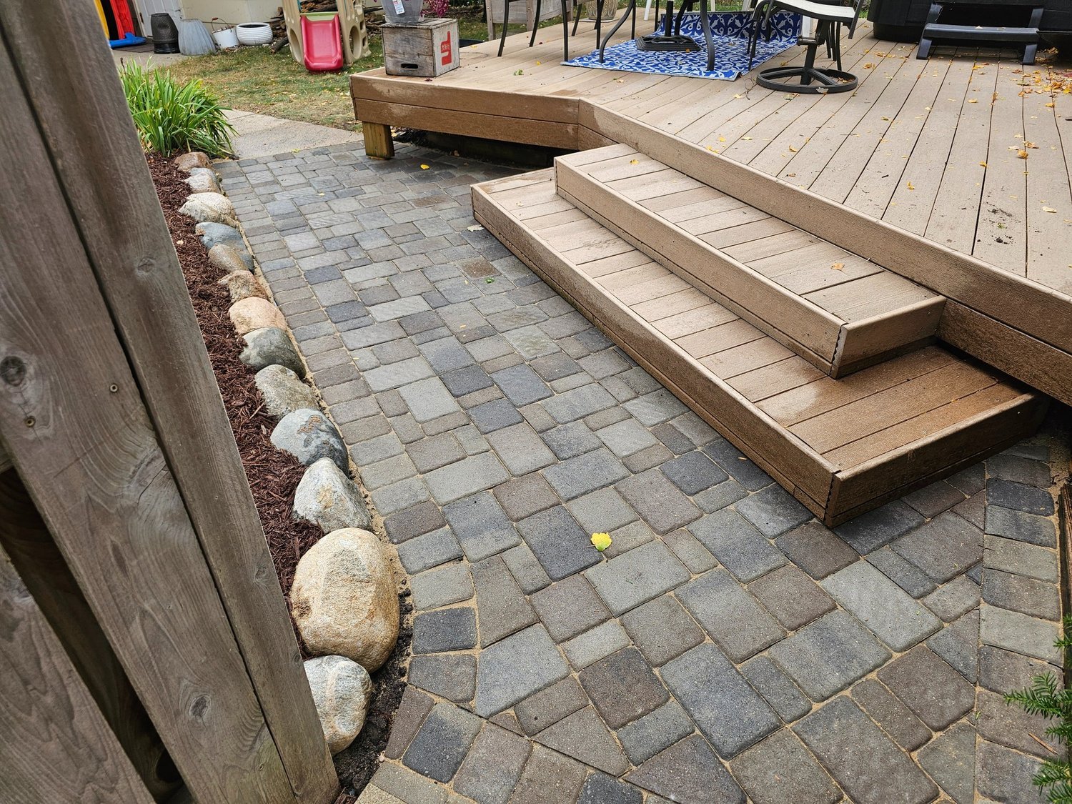 Completed Willow Creek Cobblestone paver landing at base of composite deck stairs — Longfellow Minneapolis MN — Heritage Outdoors 2024