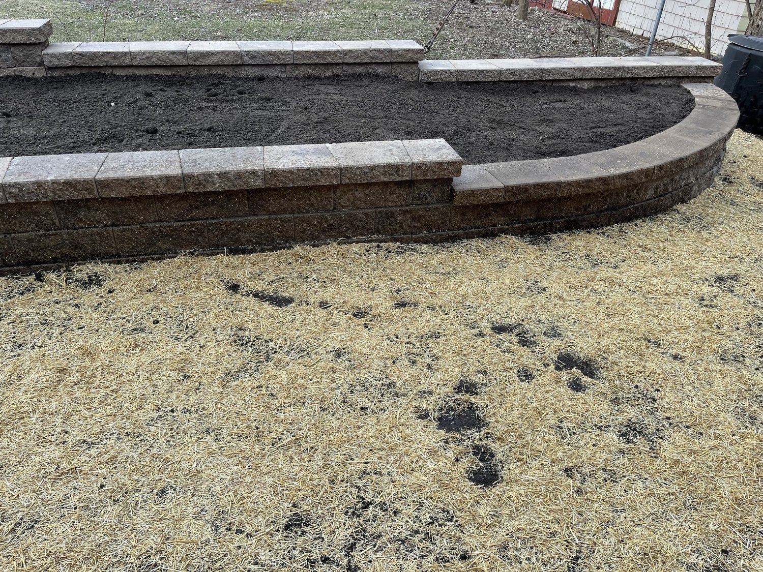 Completed Versa-Lok tan curved planter boxes in Stillwater MN backyard — Heritage Outdoors
