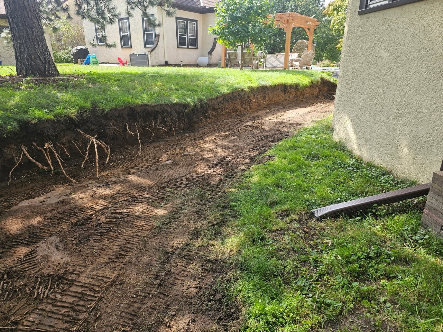 Excavated cut showing hillside grade change before Versa-Lok wall installation — Saint Paul — Heritage Outdoors 2025