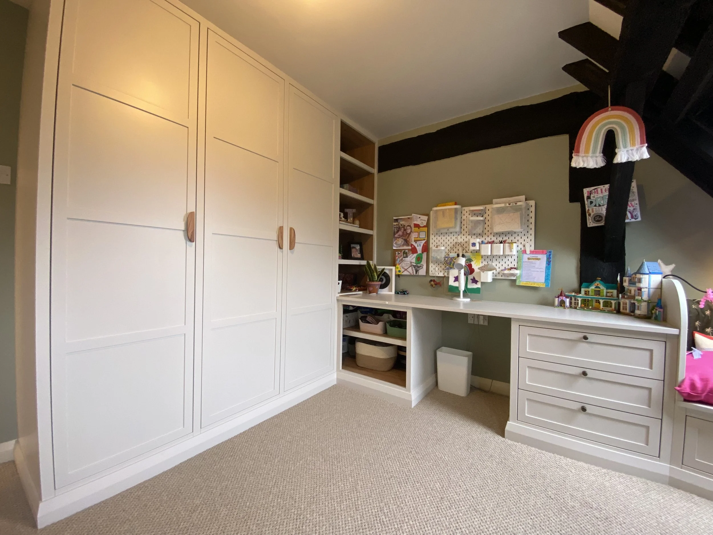 Bedroom fitted furniture maximises the space available.  In this gir's bedroom, there's a combination of floor to ceiling wardrobes for clothes, shelf space for personal items and a desk with drawers for stationary and bits and bobs.  The cupboard do