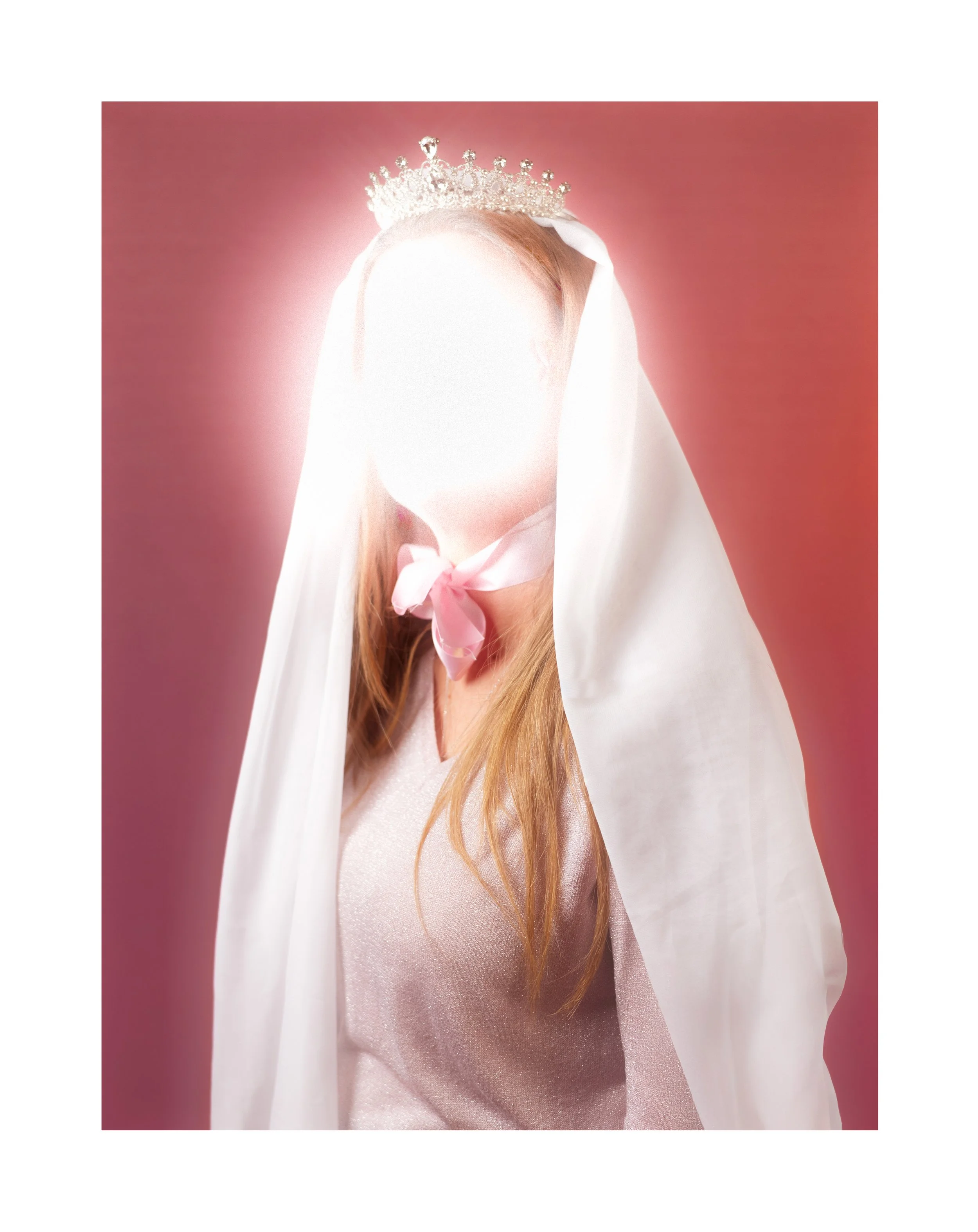 Une personne portant une couronne de princesse, un voile blanc, une robe rose pâle et un ruban rose au cou, contre un fond rose.