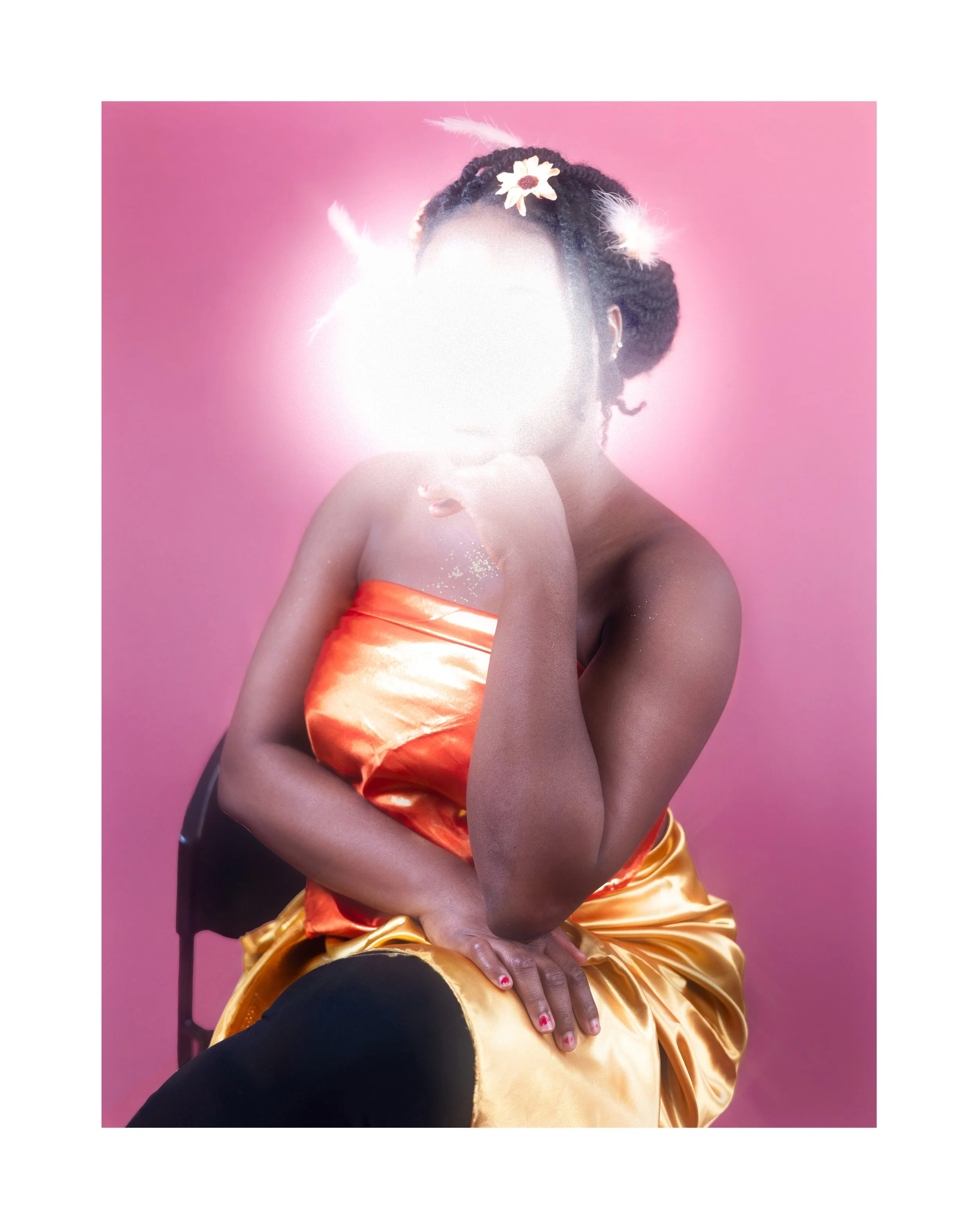 Personne assise dont le visage est flouté, portant une robe orange en satin, avec une coiffure décorée de fleurs et de plumes, contre un fond rose.