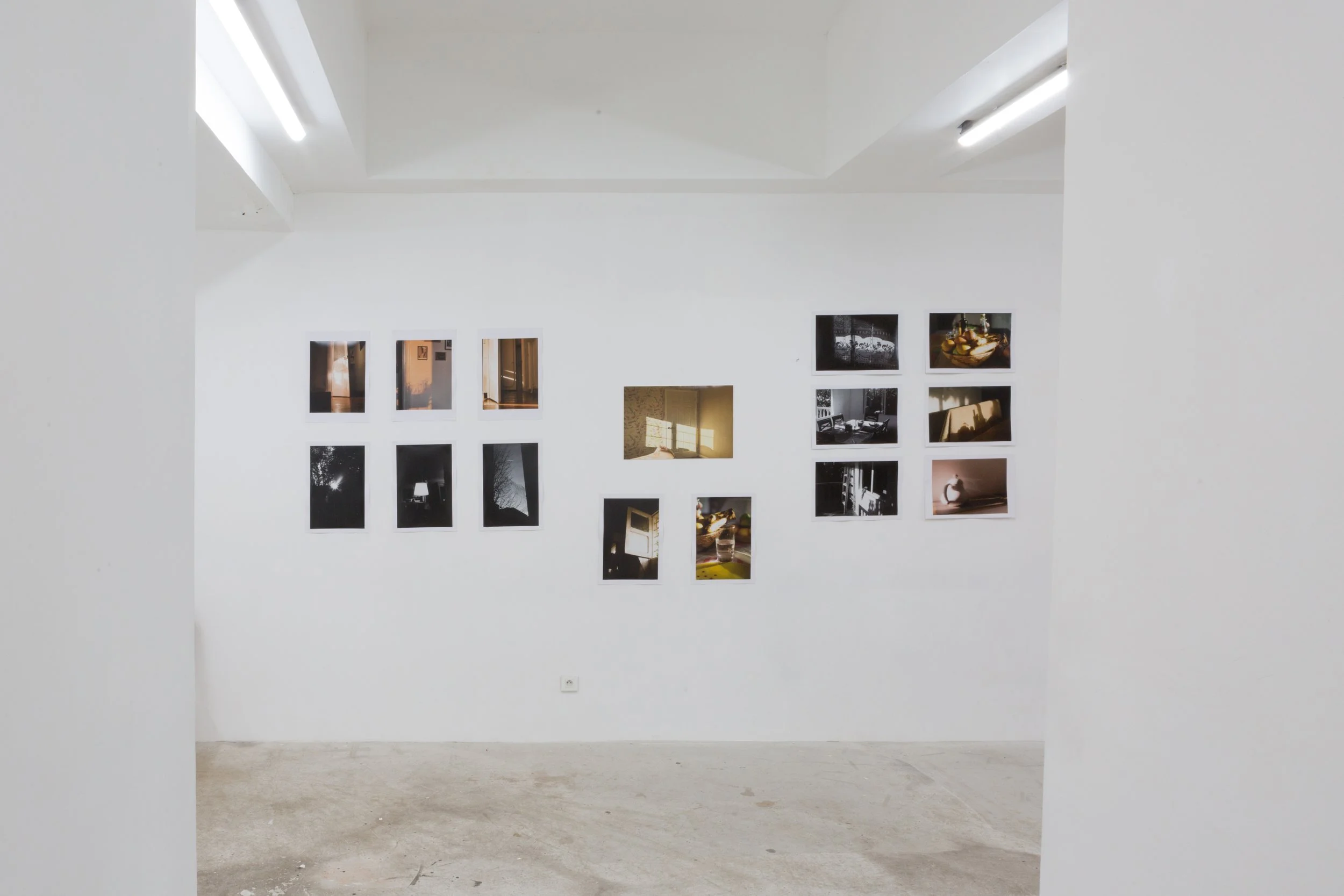 Exposition de photographies modernes sur un mur blanc, organisée dans un espace d'art ou galerie.