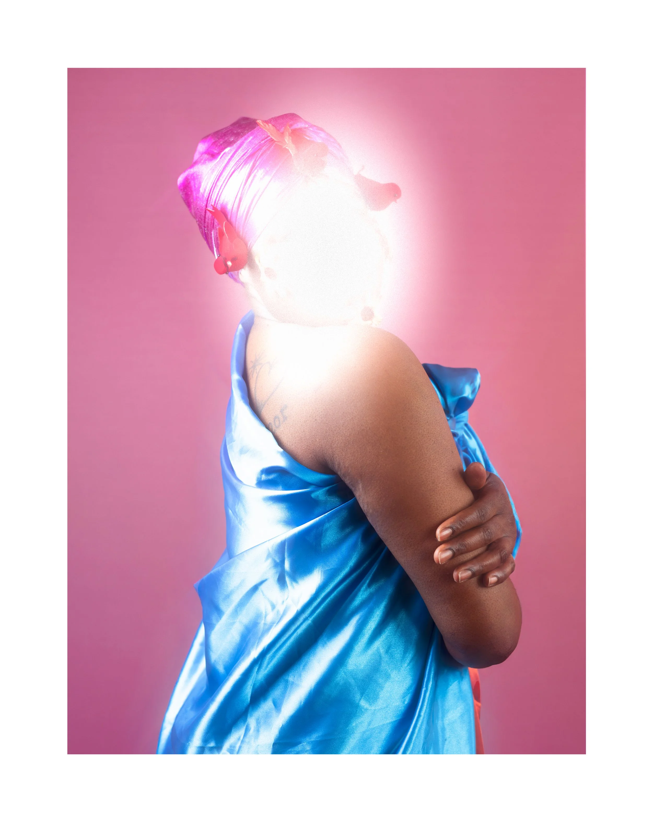 Portrait d'une personne portant une robe en satin bleu, avec un bandeau rose sur la tête, avec un fond rose, le visage flou et lumineux.