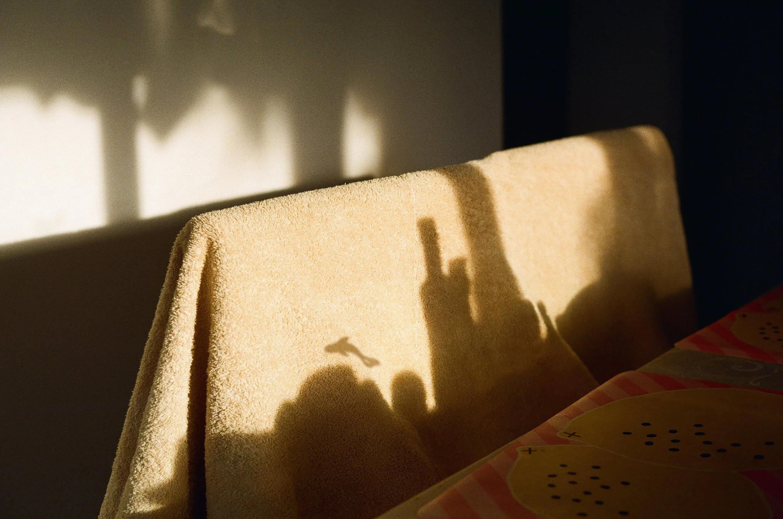 Photo en Colombie. Ombres de bouteilles et d'objets visibles sur un dossier de canapé dans la lumière du soleil.