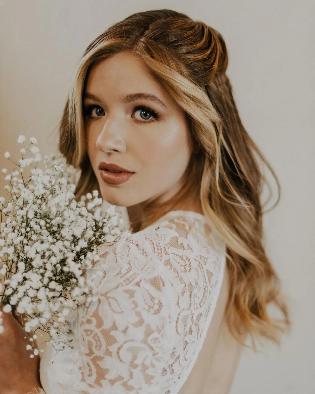 Beautiful bride adorned with baby's breath, showcasing her stunning boho glam wedding makeup