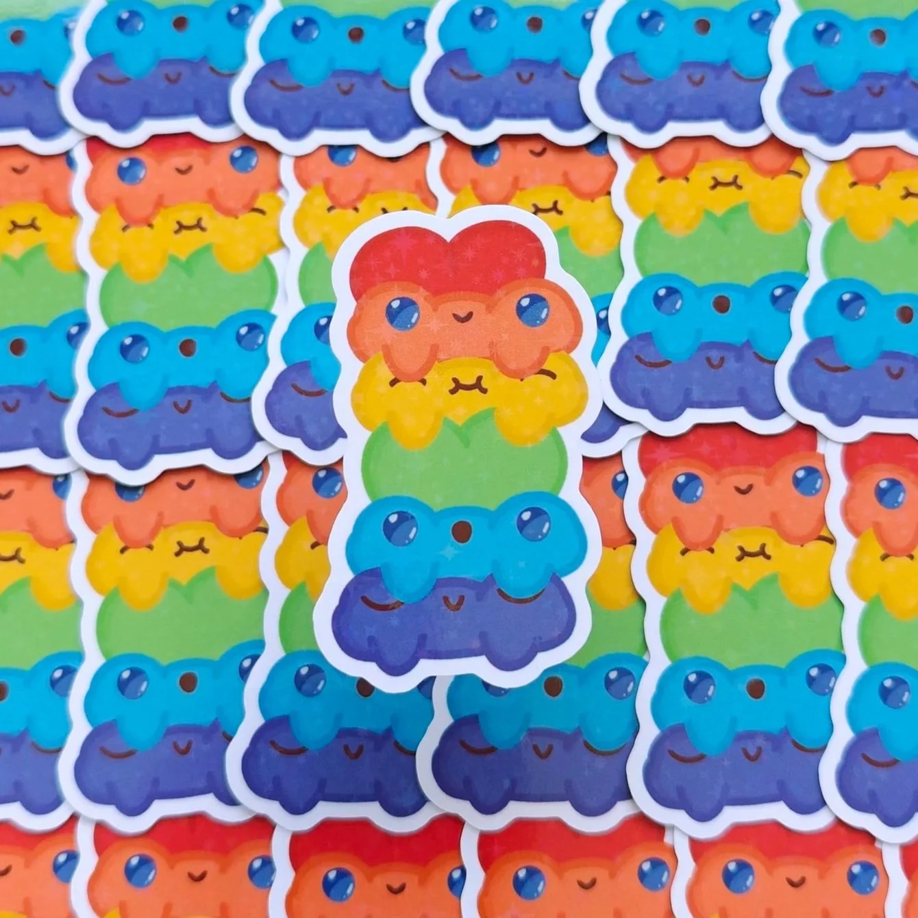 Colorful vinyl stickers featuring cartoon rainbow frogs with smiling faces.