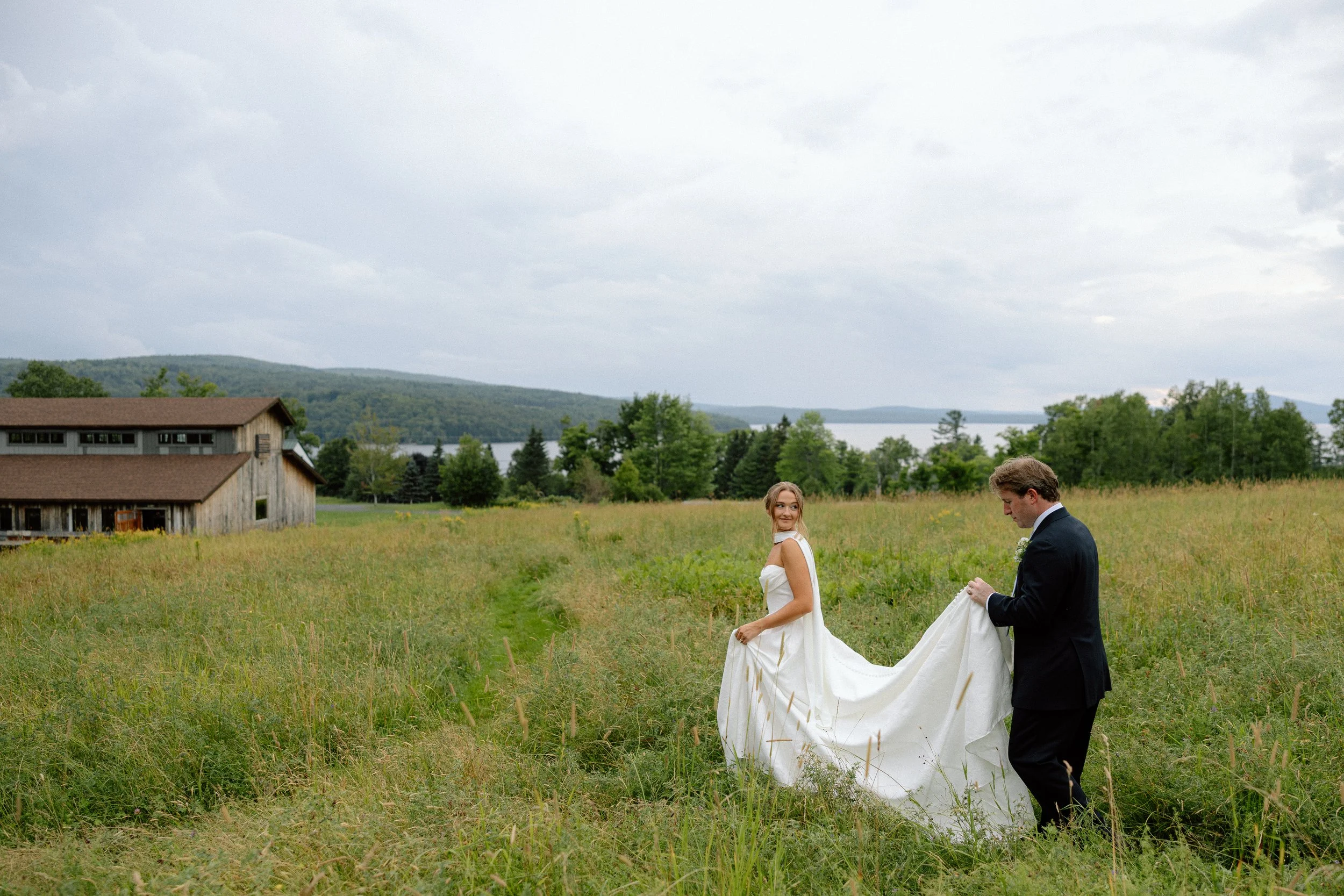 Western Maine Lakeside Wedding Couple walking in a field