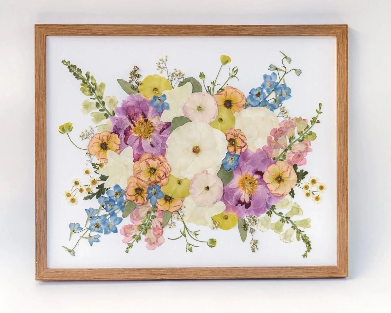 Framed watercolor painting of various colorful flowers in a floral arrangement.