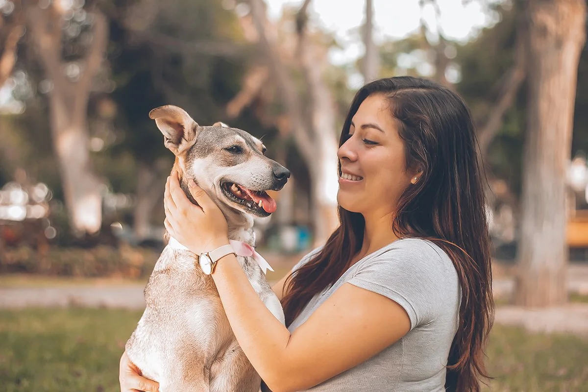 Woman hugs dog in park