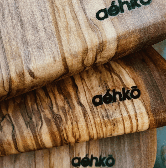 Close-up of three wooden cutting boards with the brand name 'Aêhko' engraved on them.